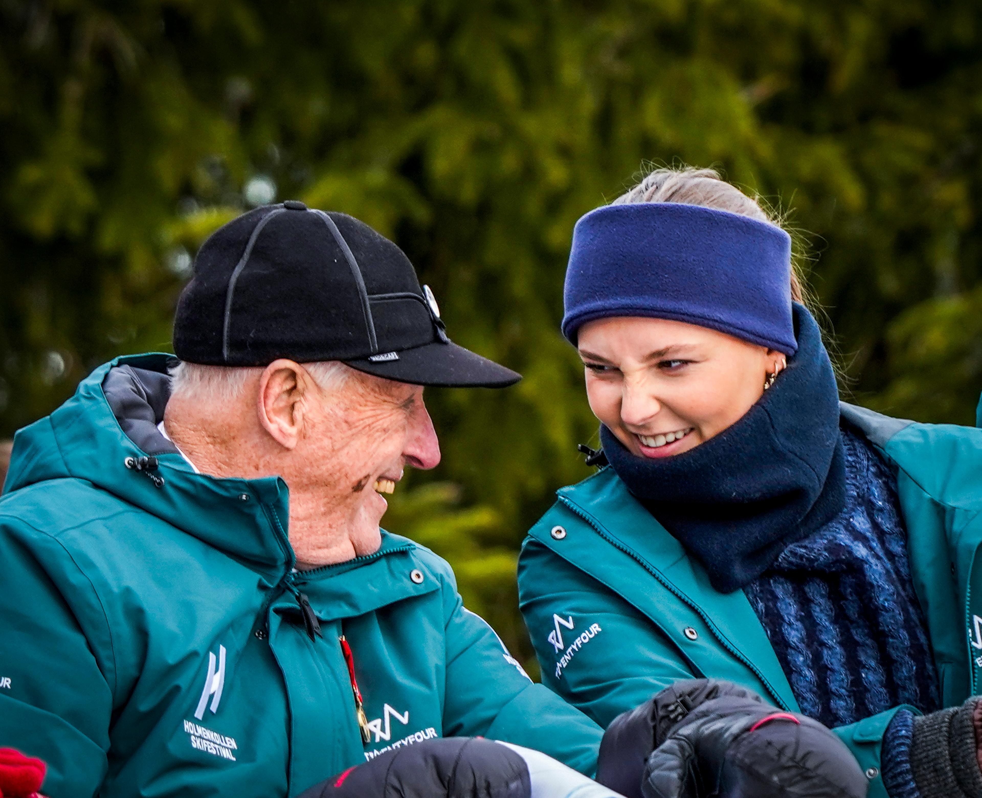 Kong Harald og Prinsesse Ingrid Alexandra ser lurt på hverandre, godt kledd i det klare vinterværet.