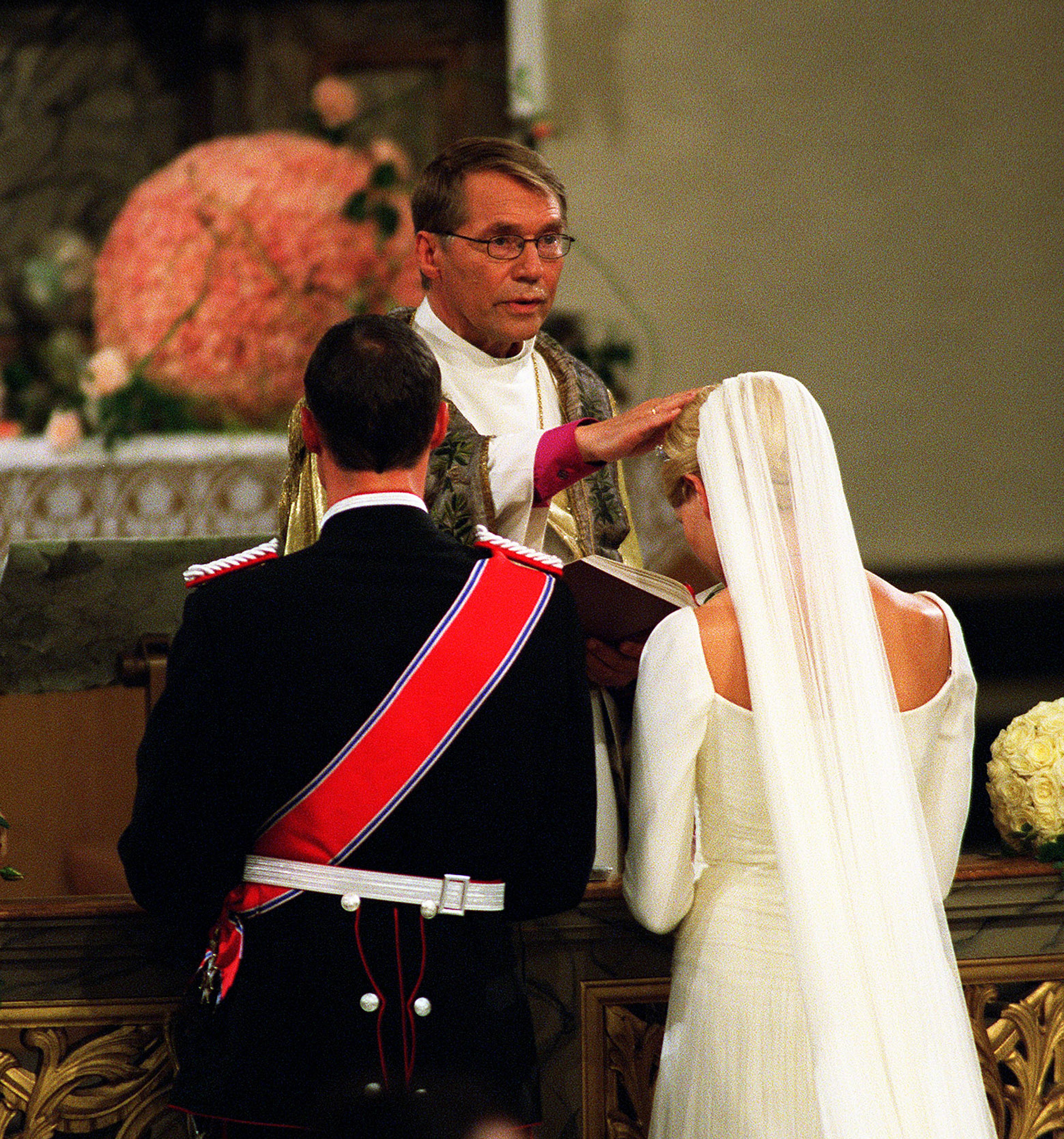 Oslos biskop, Gunnar Stålset legger hånden på hodet til Kronprinsesse Mette-Marit, mens de kneler.