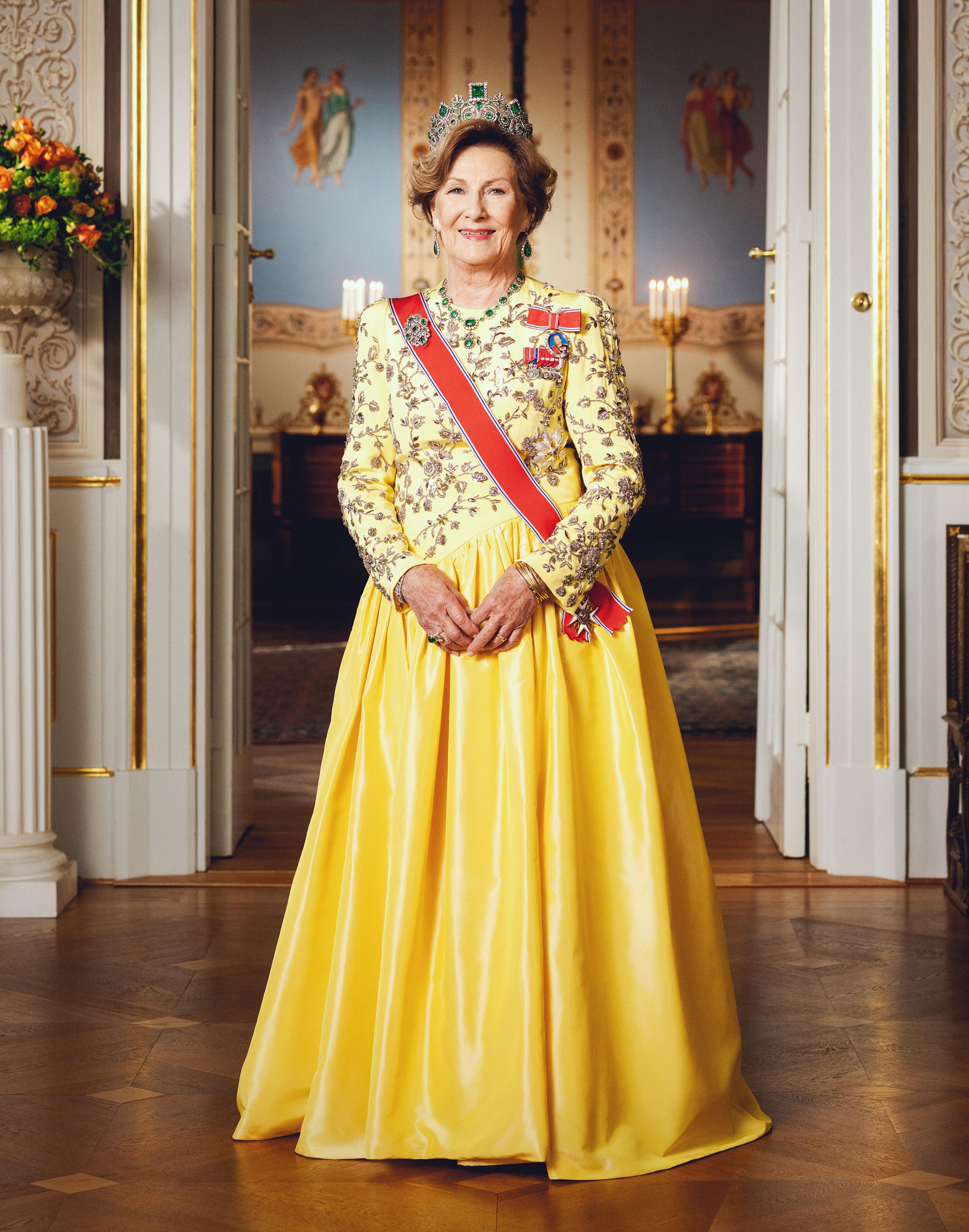 Portrett av Dronning Sonja i gallakjole med ordensbånd og medaljer. Dronningen ser rett på deg.