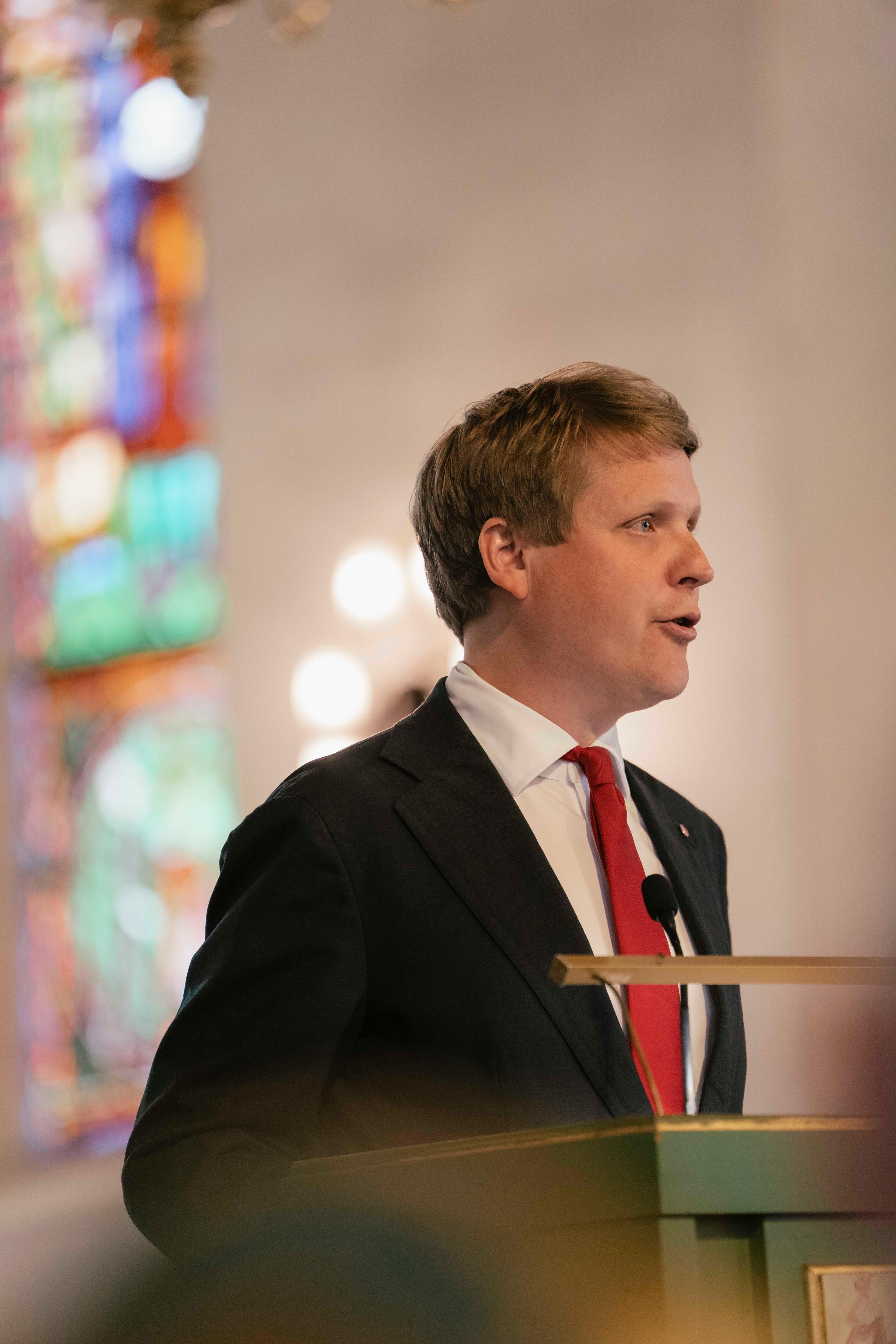 Utviklingsministeren står ved talerstolen i kirken og snakker i en mikrofon