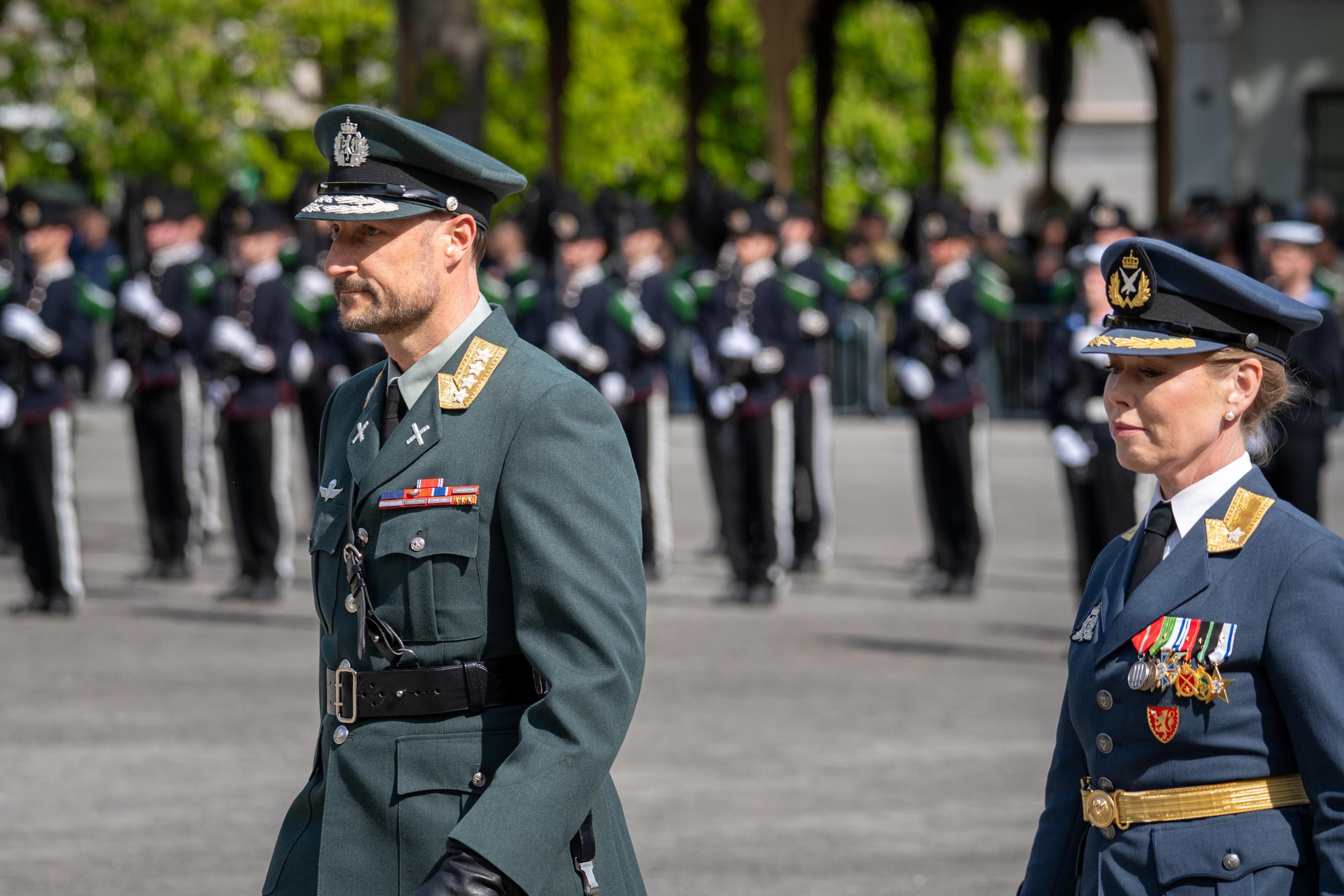 Tett på Kronprins Haakon og Gyda Ellefsplass Olssen som marsjerer over grusplassen.