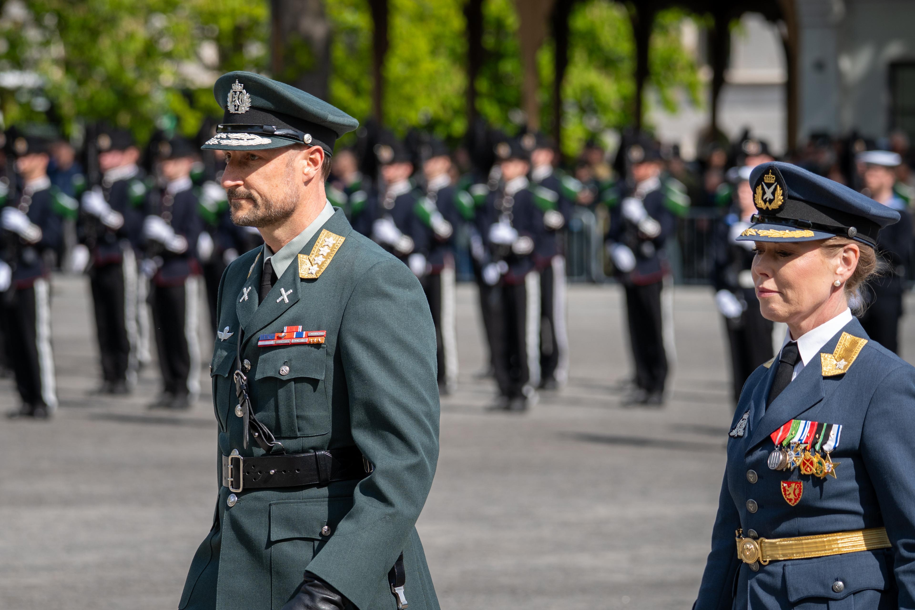 Tett på Kronprins Haakon og Gyda Ellefsplass Olssen som marsjerer over grusplassen.