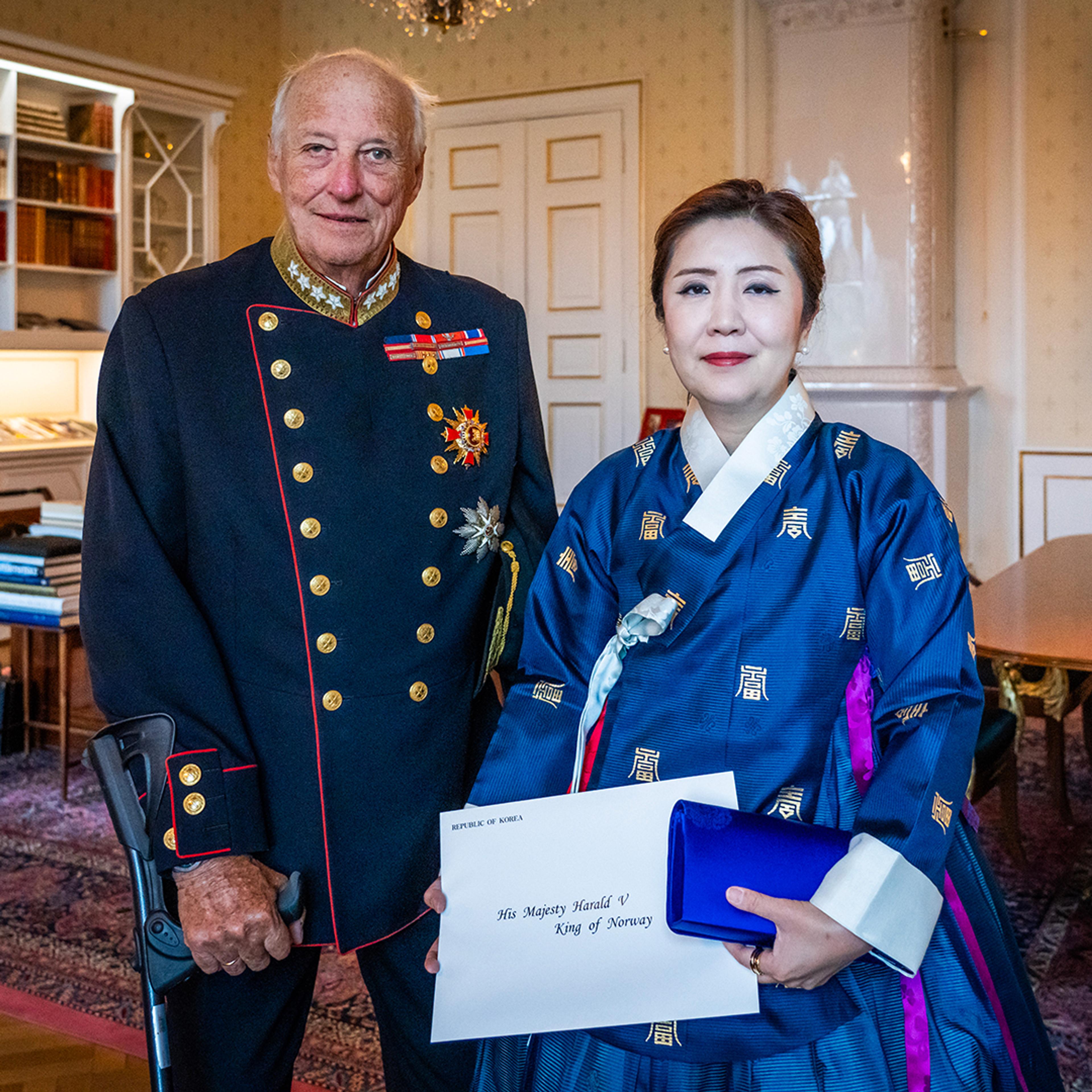 Kongen og ambassadøren står smilende sammen på Kongens kontor. Ambassadøren holder sine akkreditiver i hendene.