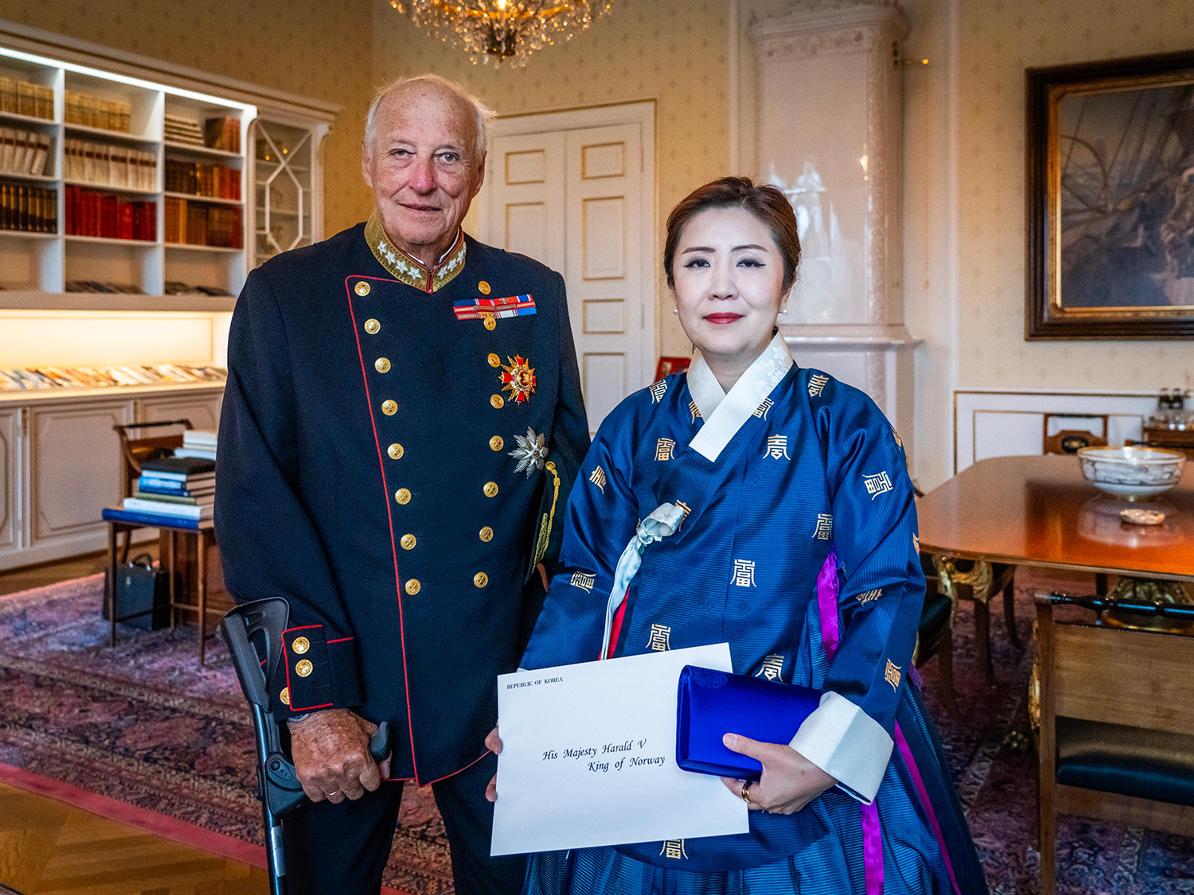 Kongen og ambassadøren står smilende sammen på Kongens kontor. Ambassadøren holder sine akkreditiver i hendene.