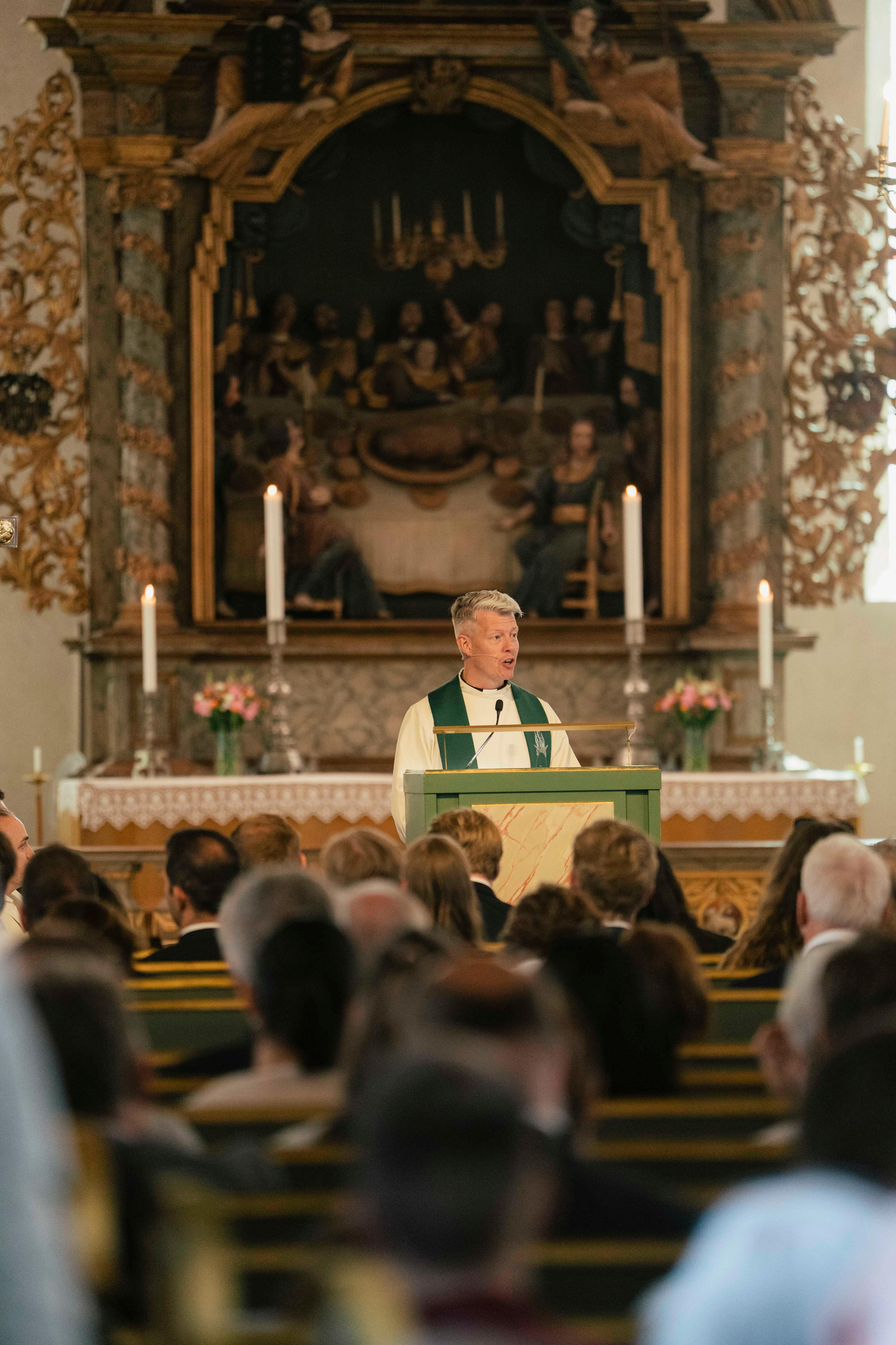 Domprosten holder sin preken i Oslo domkirke. Flere mennesker er samlet i forgrunnen for å se