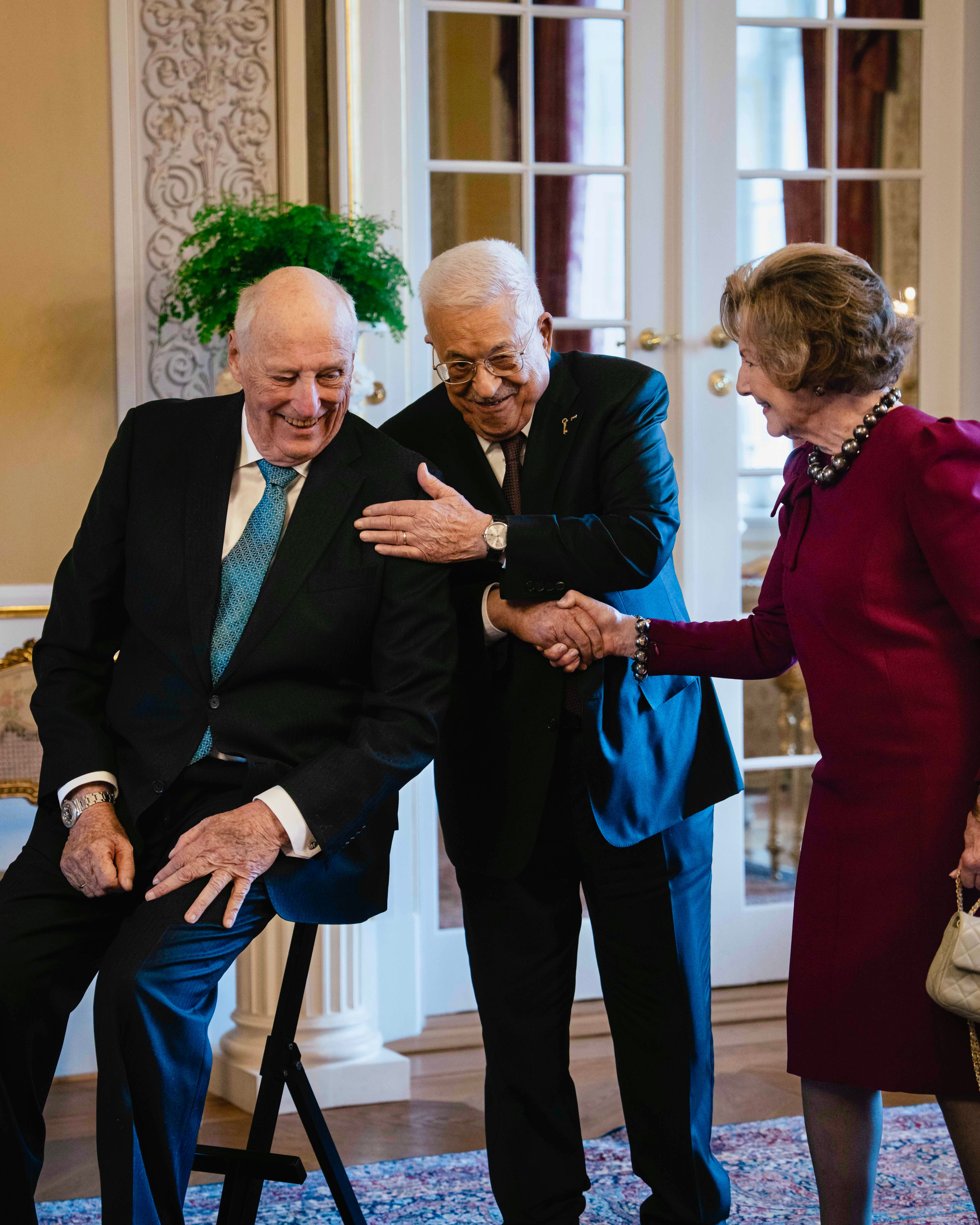Kong Harald, president Mahmoud Abbas og Dronning Sonja smiler under hilsingen.
