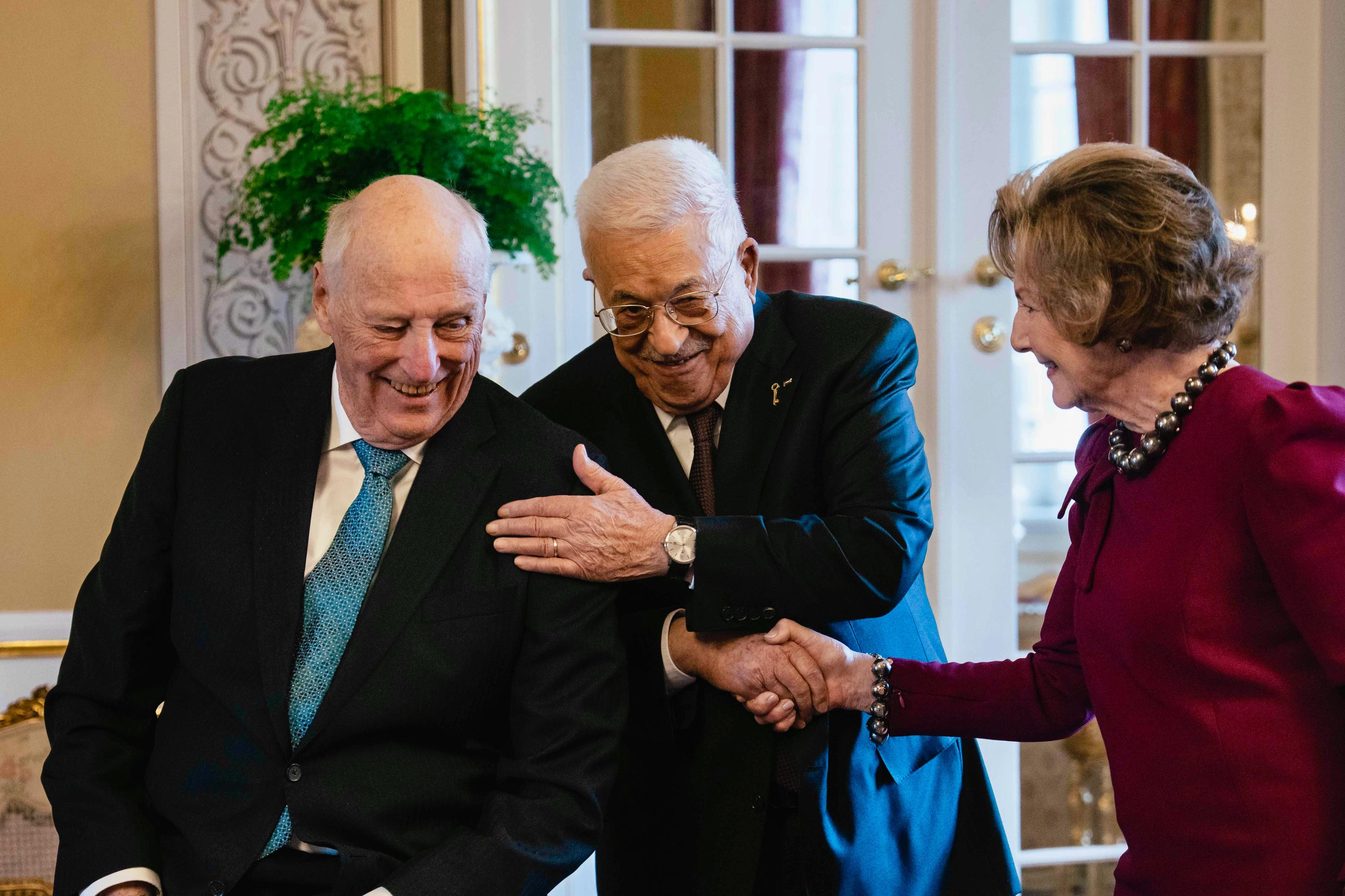 Kong Harald, president Mahmoud Abbas og Dronning Sonja smiler under hilsingen.