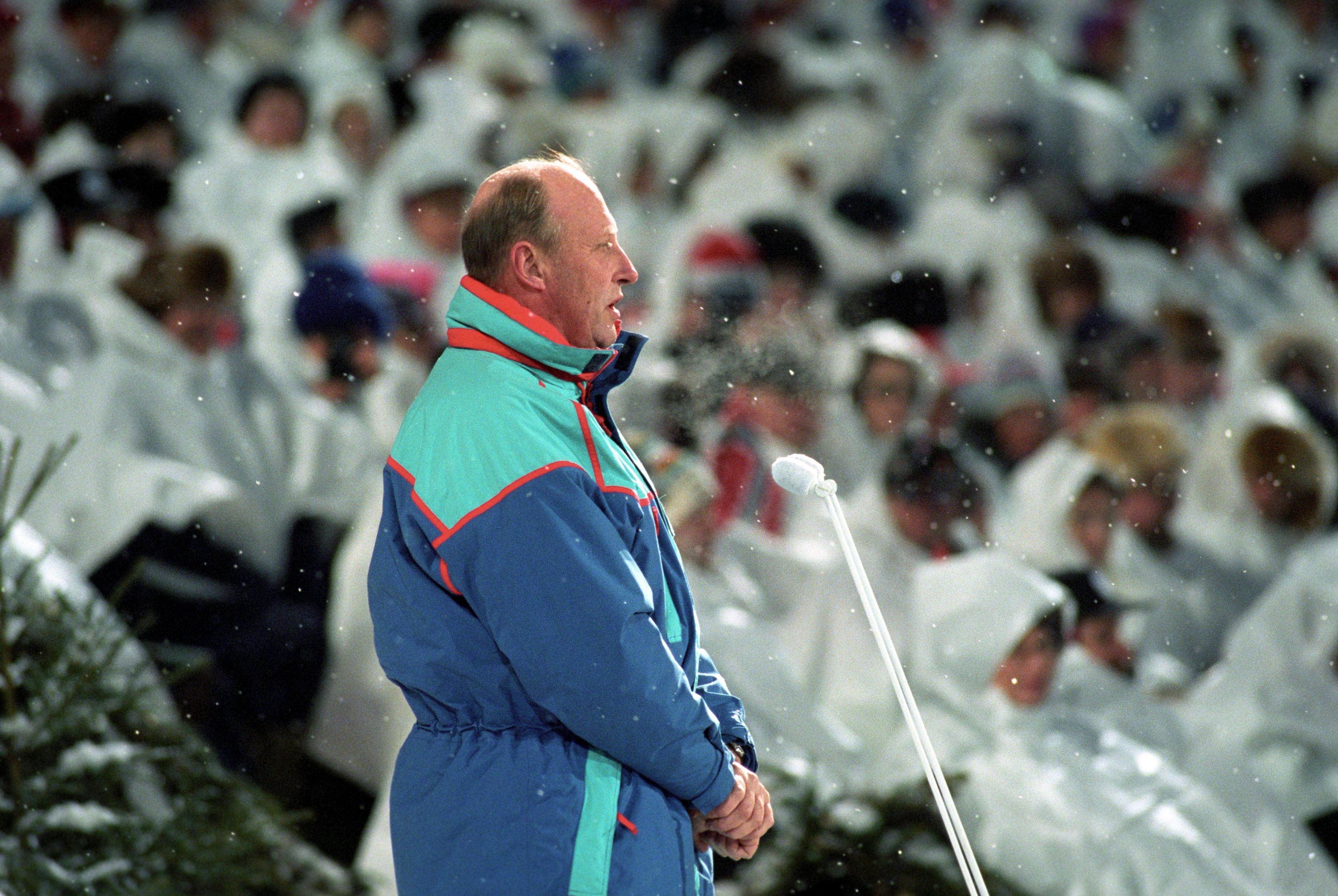 Kong Harald foran mikrofoner. Det sitter publikummere bak ham i bildet.