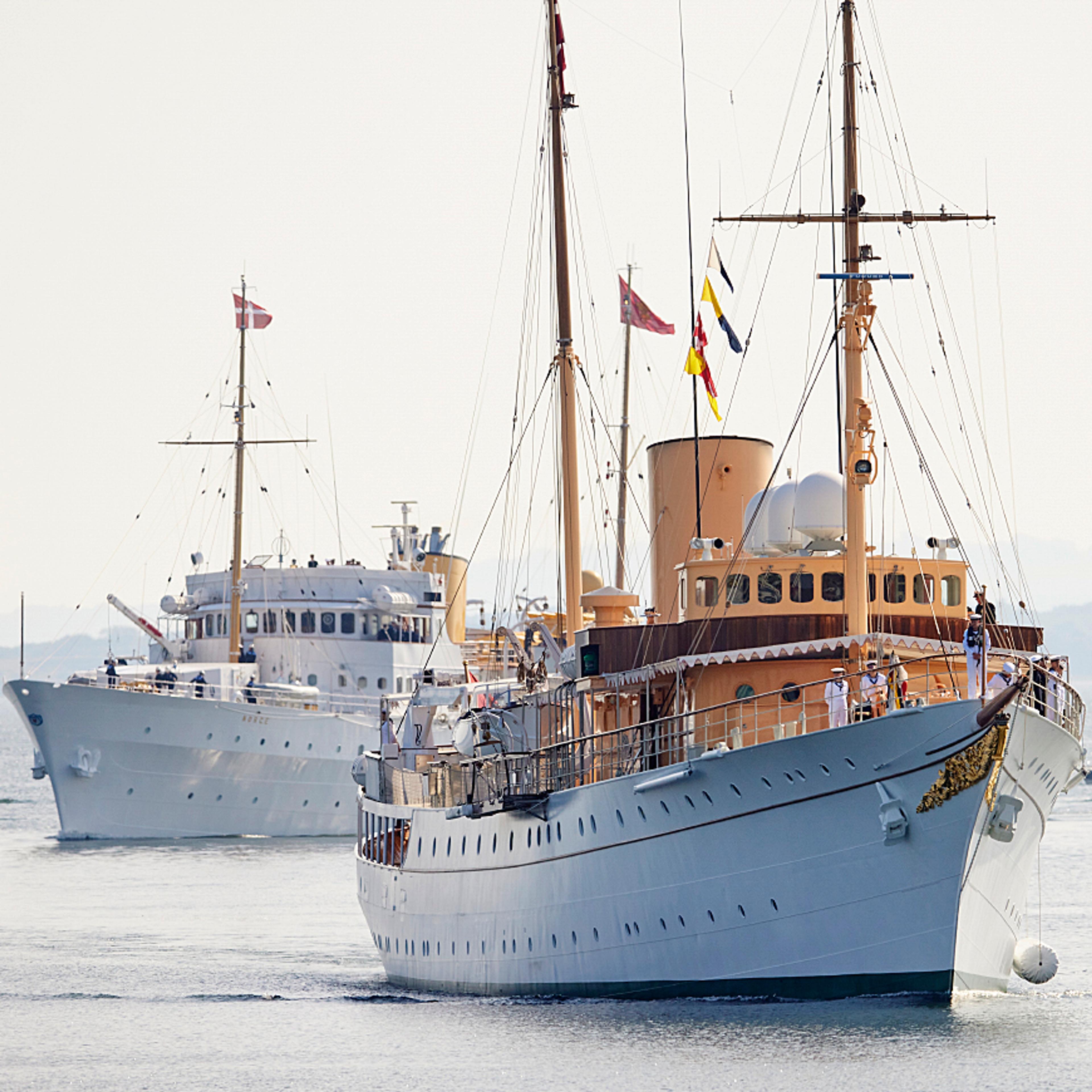 De to skipene går inn mot kai. Det norske kongeskipet først, etterfulgt av Dannebrog.