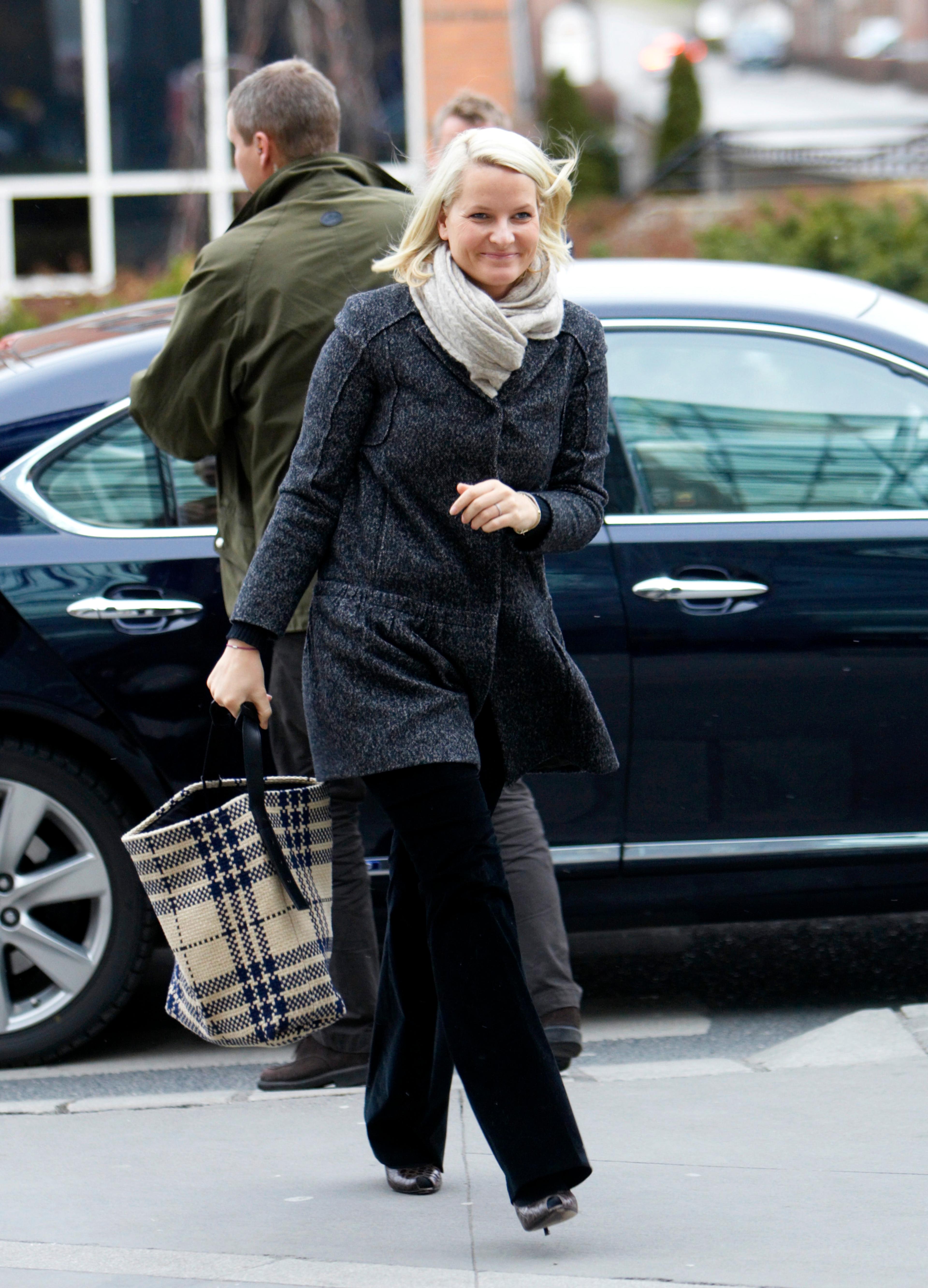 Kronprinsesse Mette-Marit kommer gående i varme klær og skjerf.