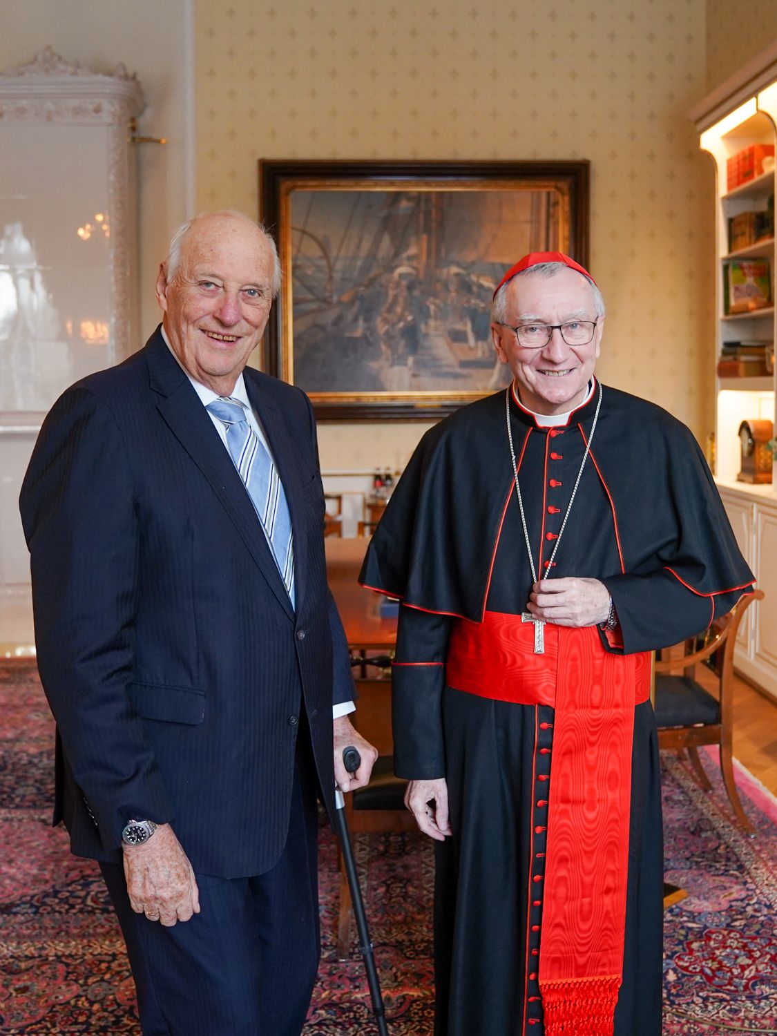Kongen og kardinalen står smilende sammen på Kongens kontor.