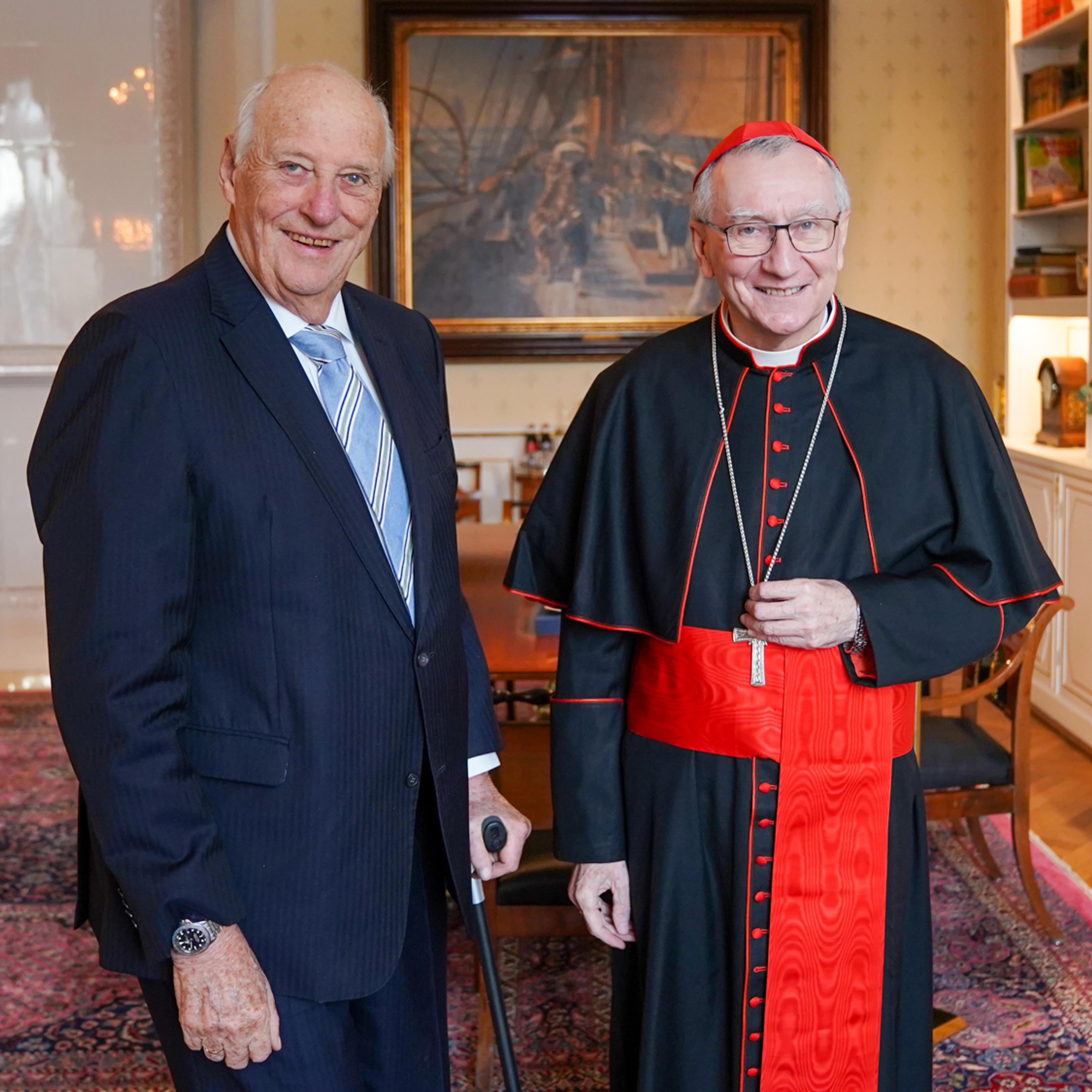 Kongen og kardinalen står smilende sammen på Kongens kontor.