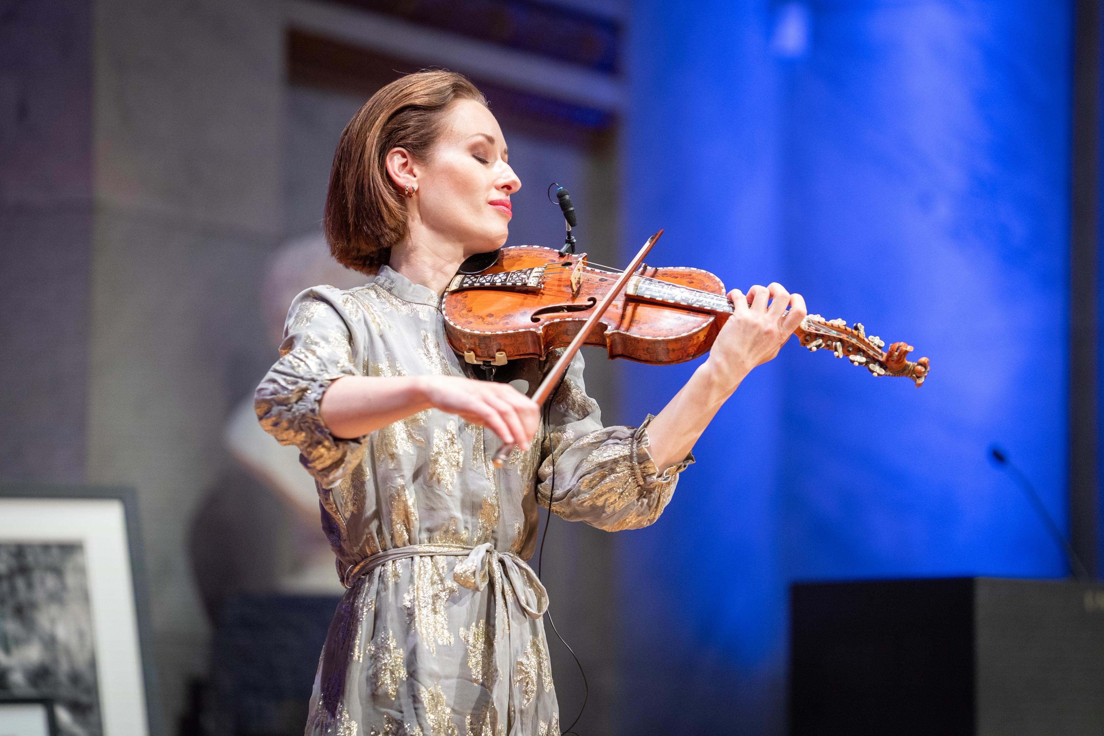 Hemsing spiller på hardingfela. Hun har øynene lukket.