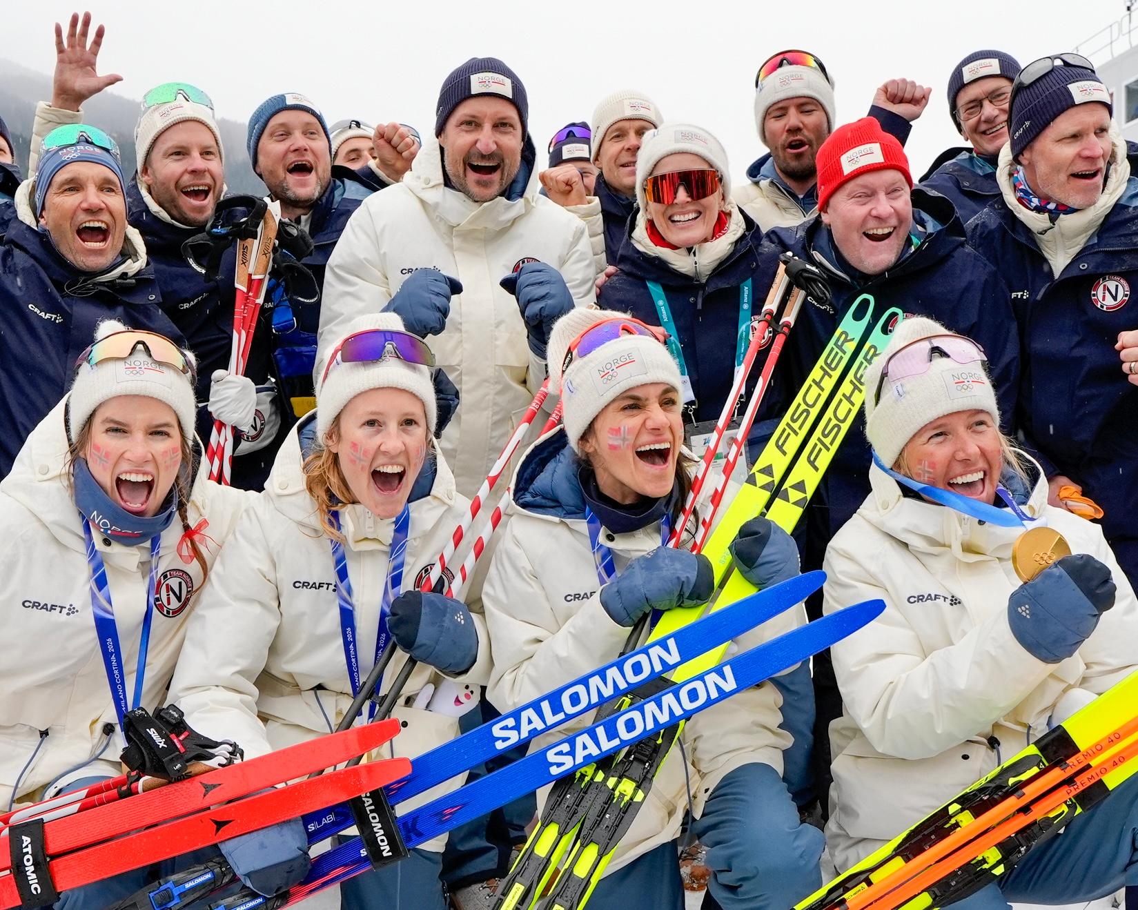 De norske gullmedaljevinnerne jubler i front, med Kronprins Haakon og støtteapparat i bakgrunnen.
