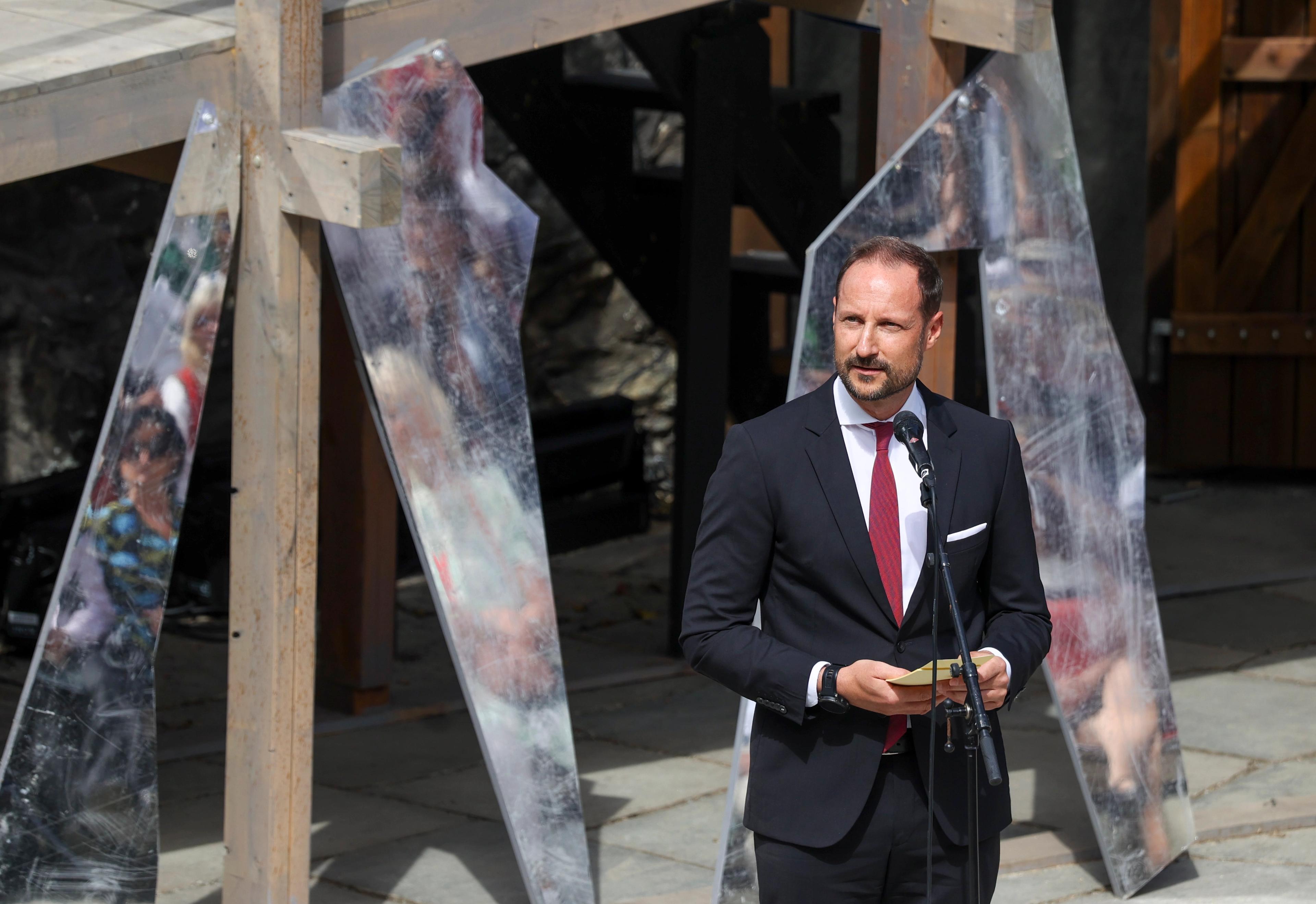 Kronprins Haakon i dress foran en mikrofon.
