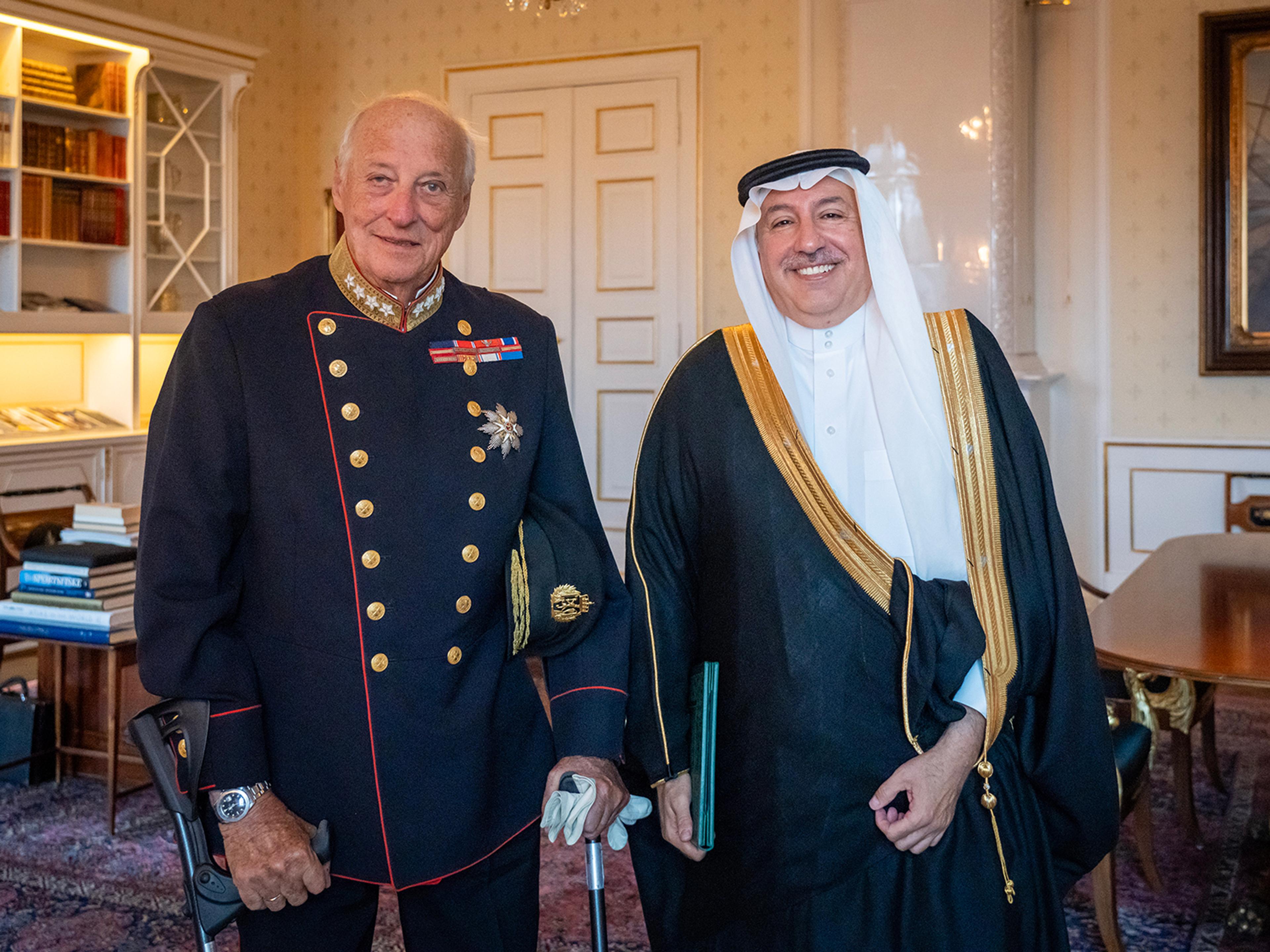 Kongen og ambassadøren står smilende ved siden av hvernadre på Kongens kontor.