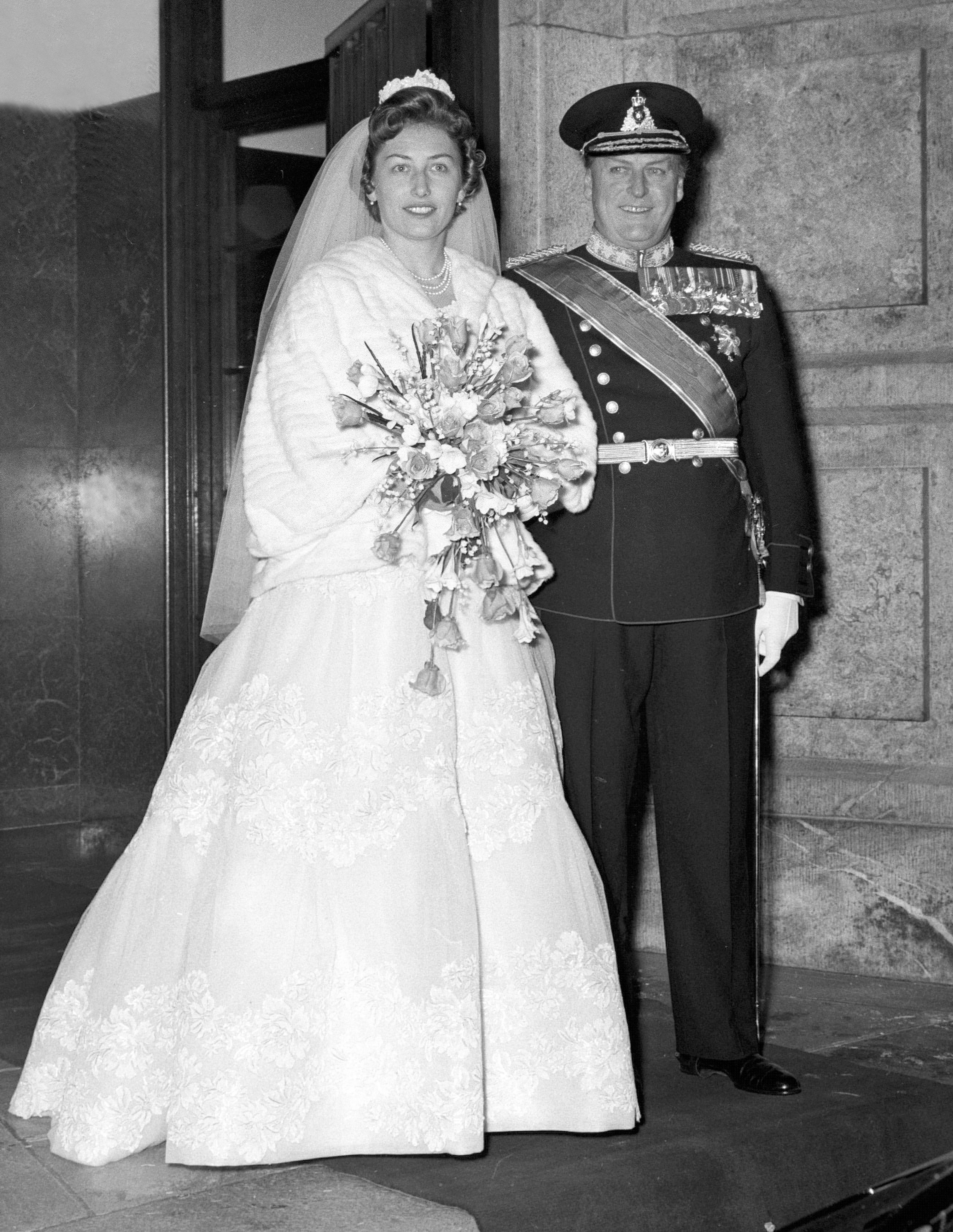 Prinsesen i brudekjole og Kong Olav i gallauniform på vei ut døren.