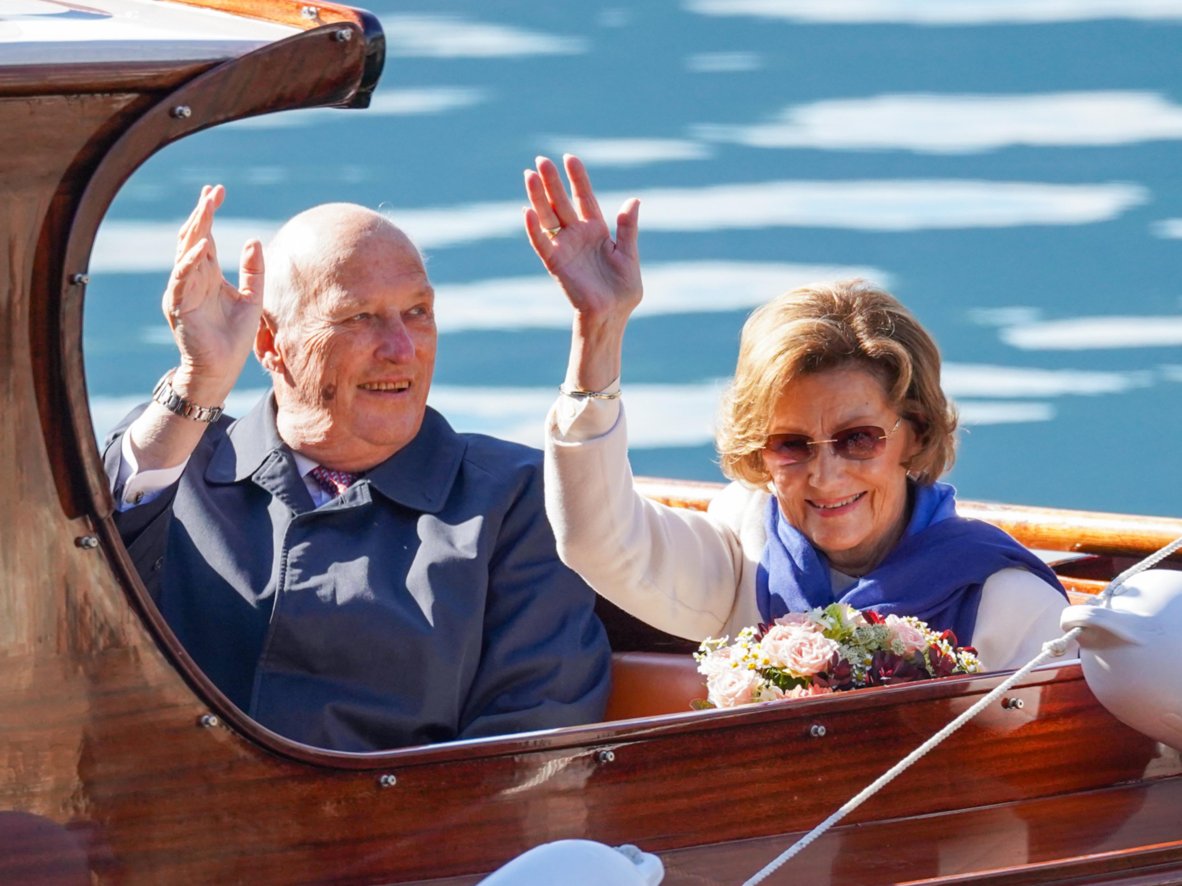 Kongen og Dronningen vinker fra sjaluppen.