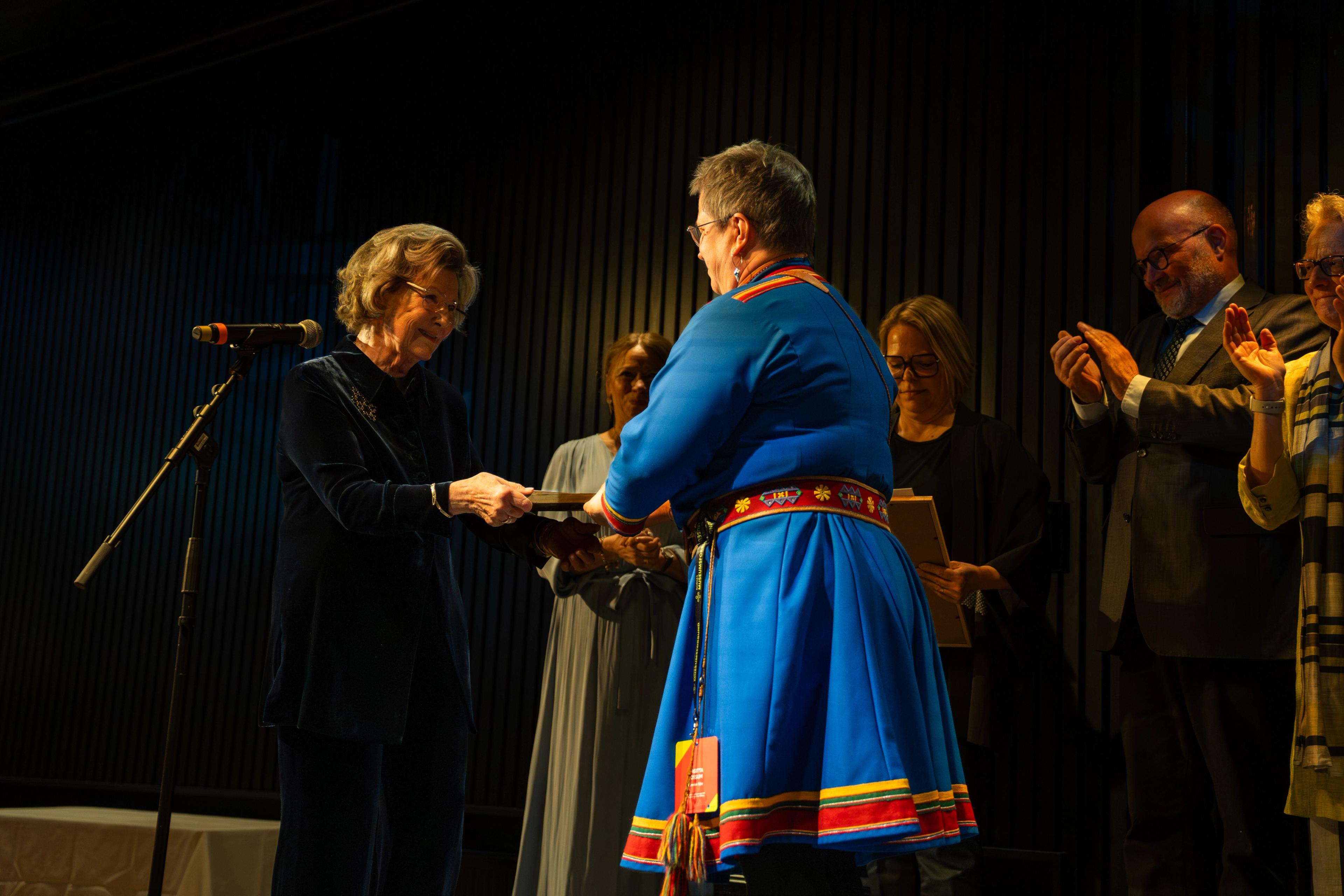 Dronningen overleverer prisen til vinneren av Årets museum på scenen.