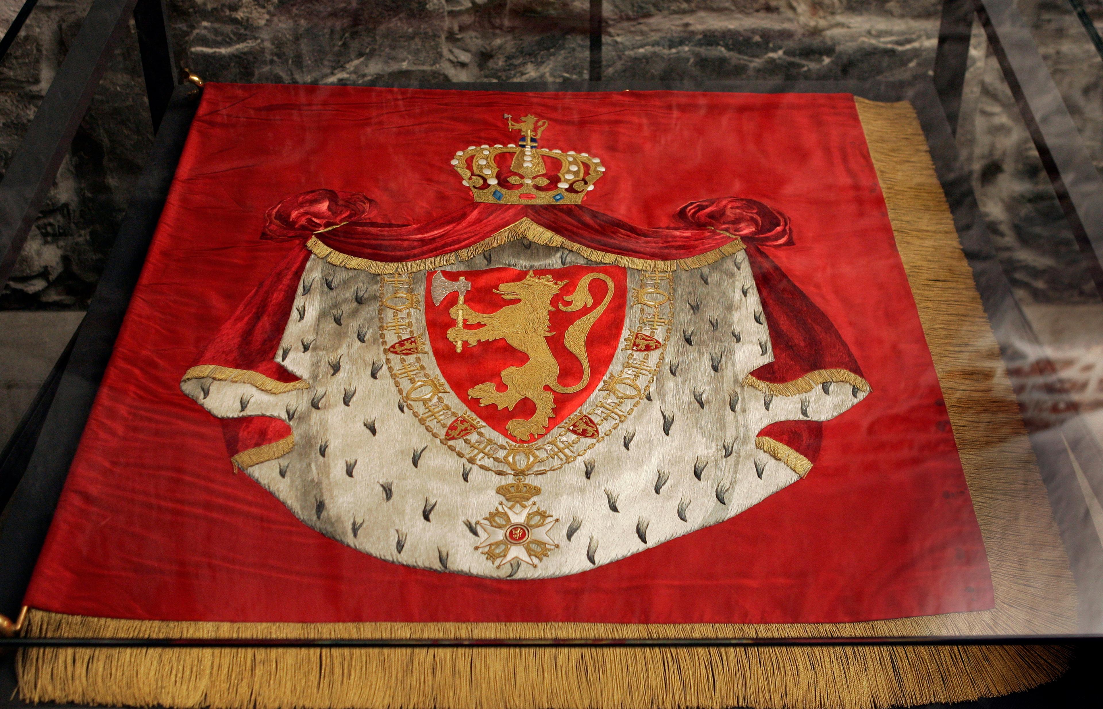 Riksbanneret er rødt og kantet med gullfrynser. I sentrum av banneret er Kongevåpenet, med Den norske løve omgitt av St. Olavs ordenskjede og hermelinkappe og krone.