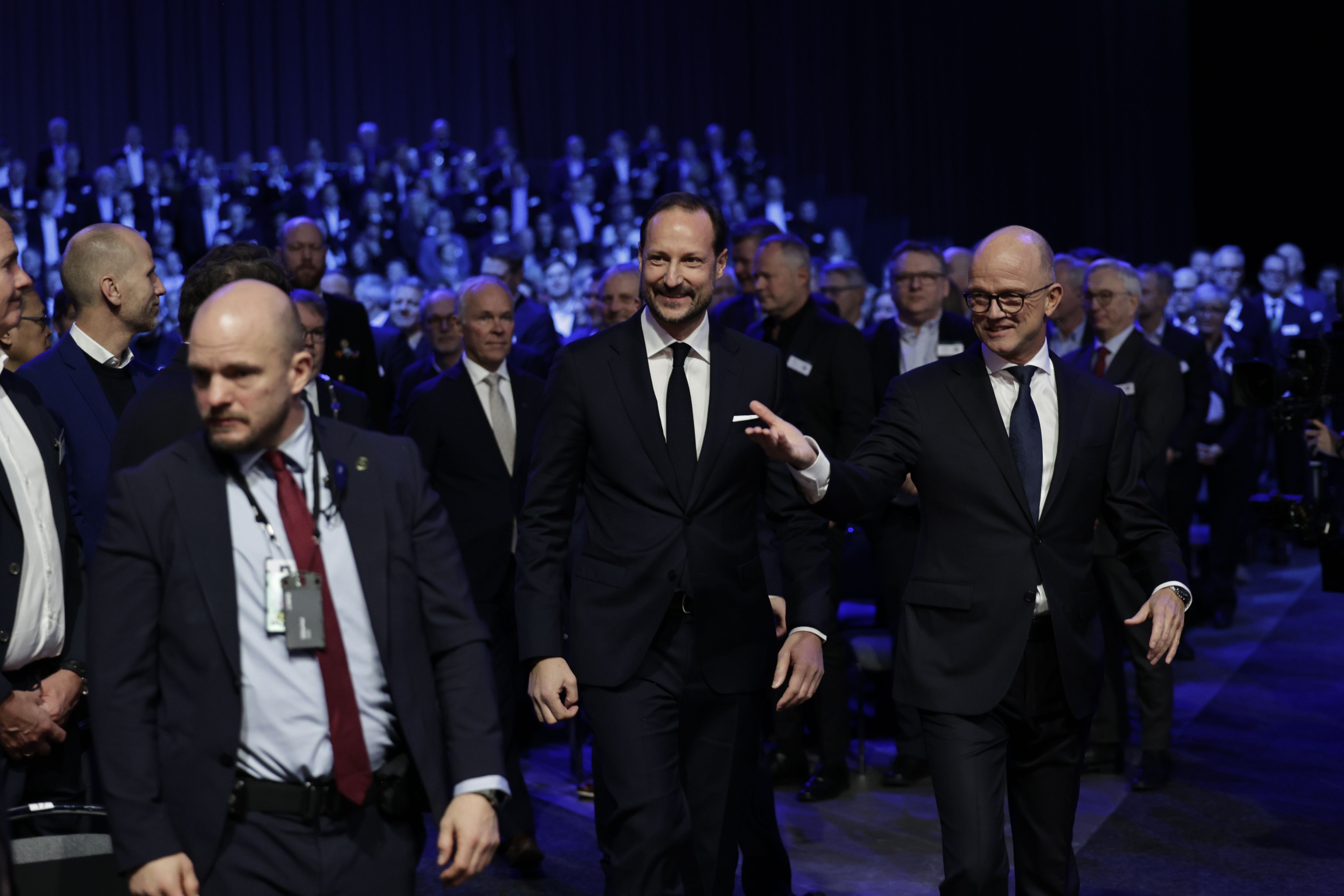 Kronprinsen ledsages inn i salen av NHO-leder Ole Erik Almlid. 