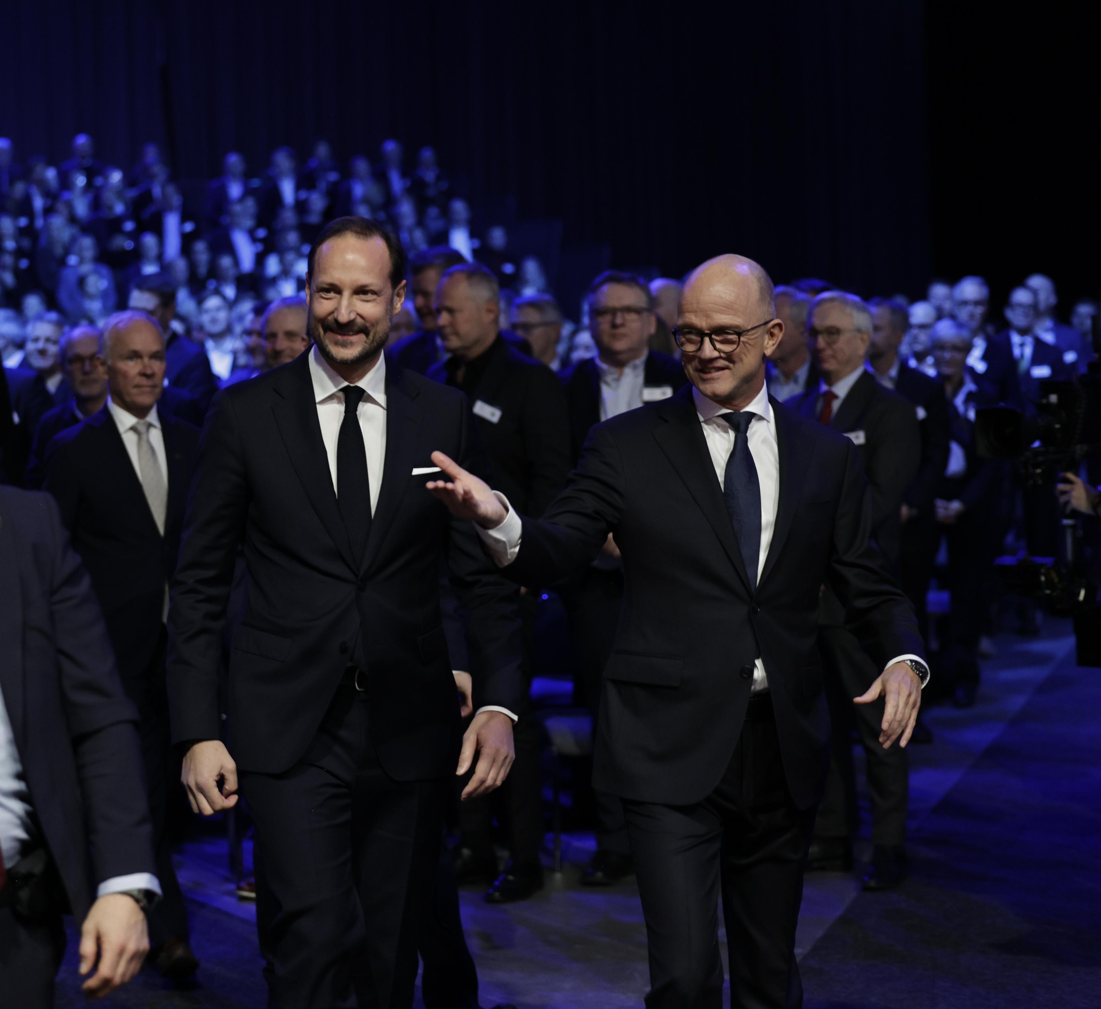 Kronprinsen ledsages inn i salen av NHO-leder Ole Erik Almlid.