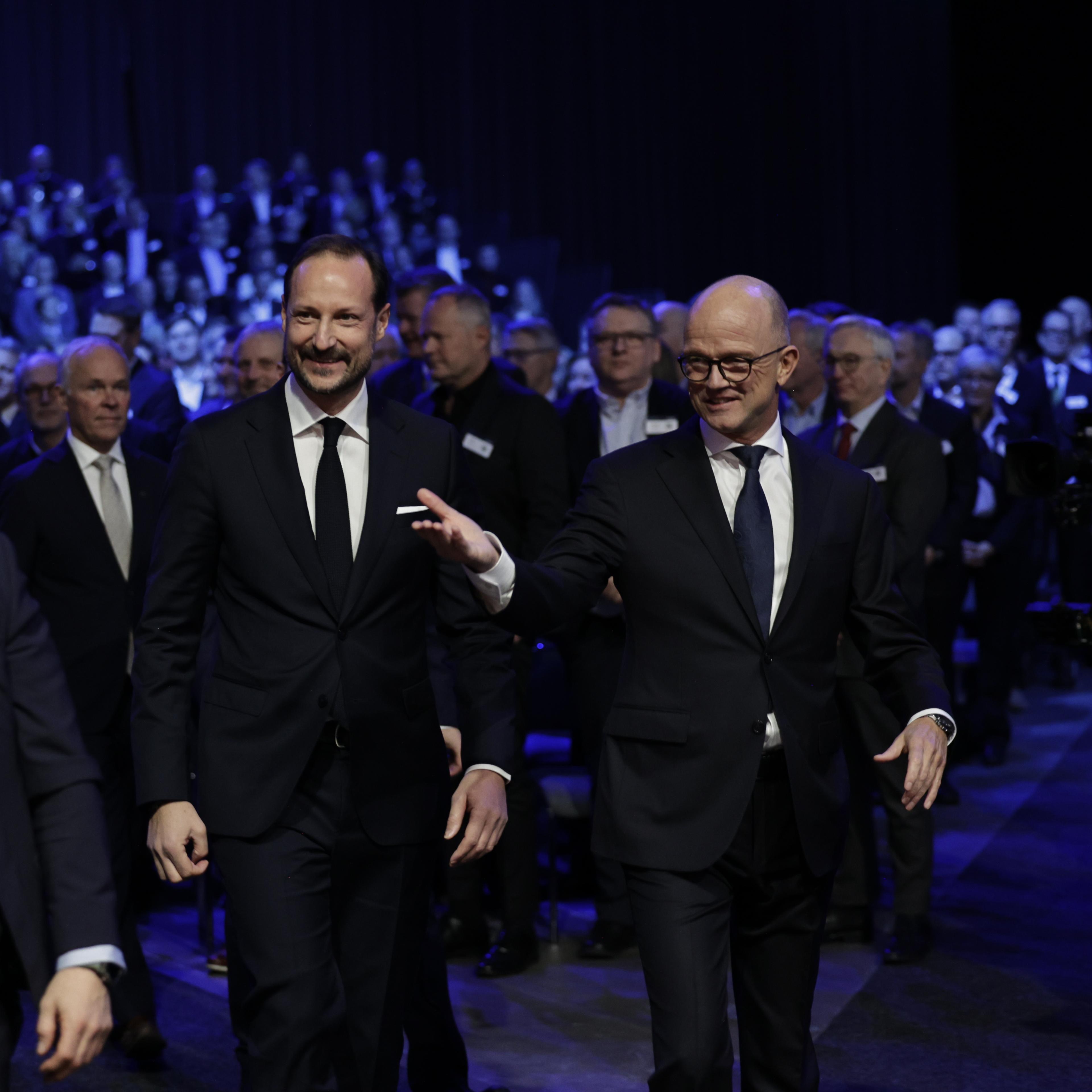 Kronprinsen ledsages inn i salen av NHO-leder Ole Erik Almlid.