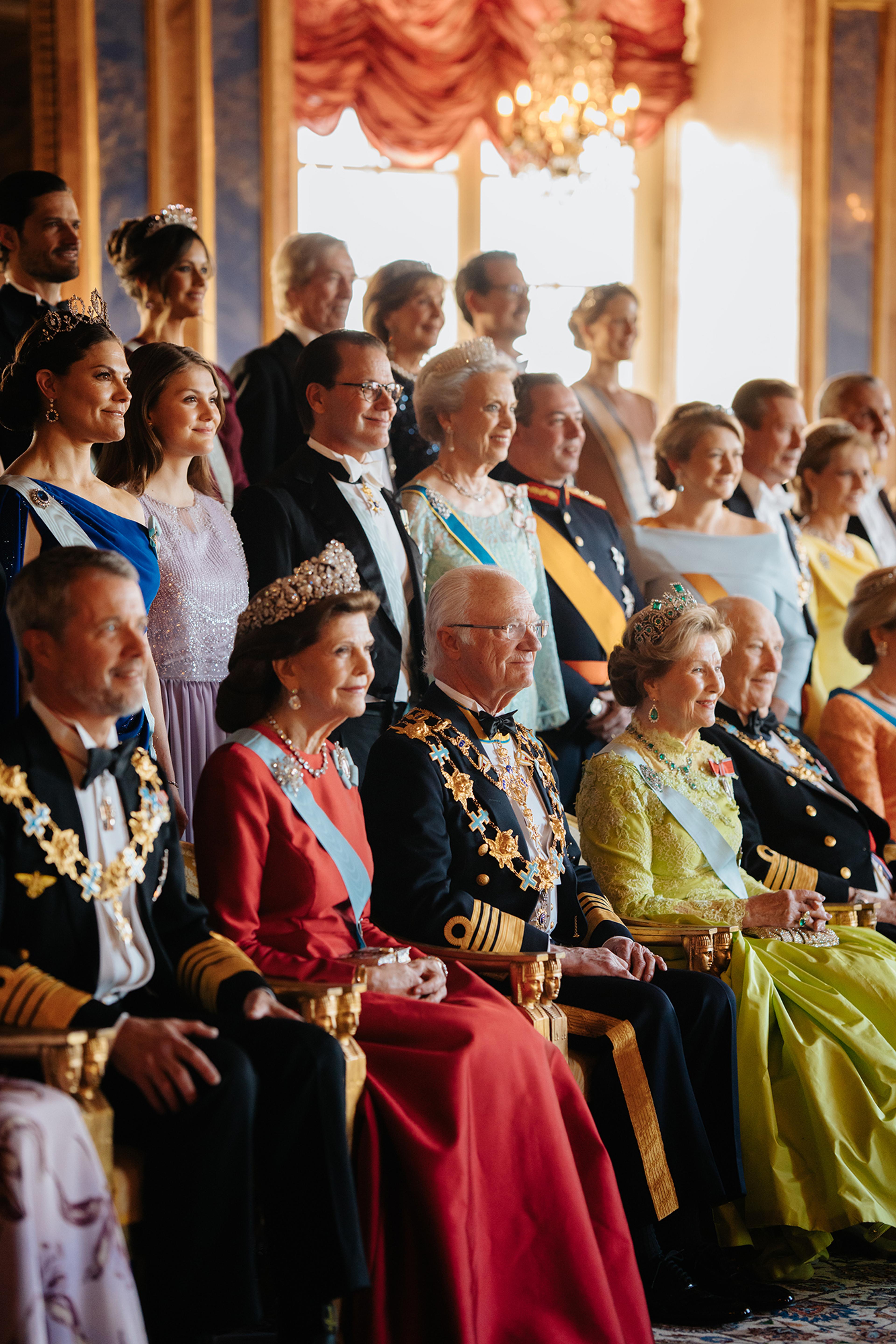 Kong Carl Gustaf sitter i sentrum av en foto-oppstilling med familie og kongelige gjester rundt seg.