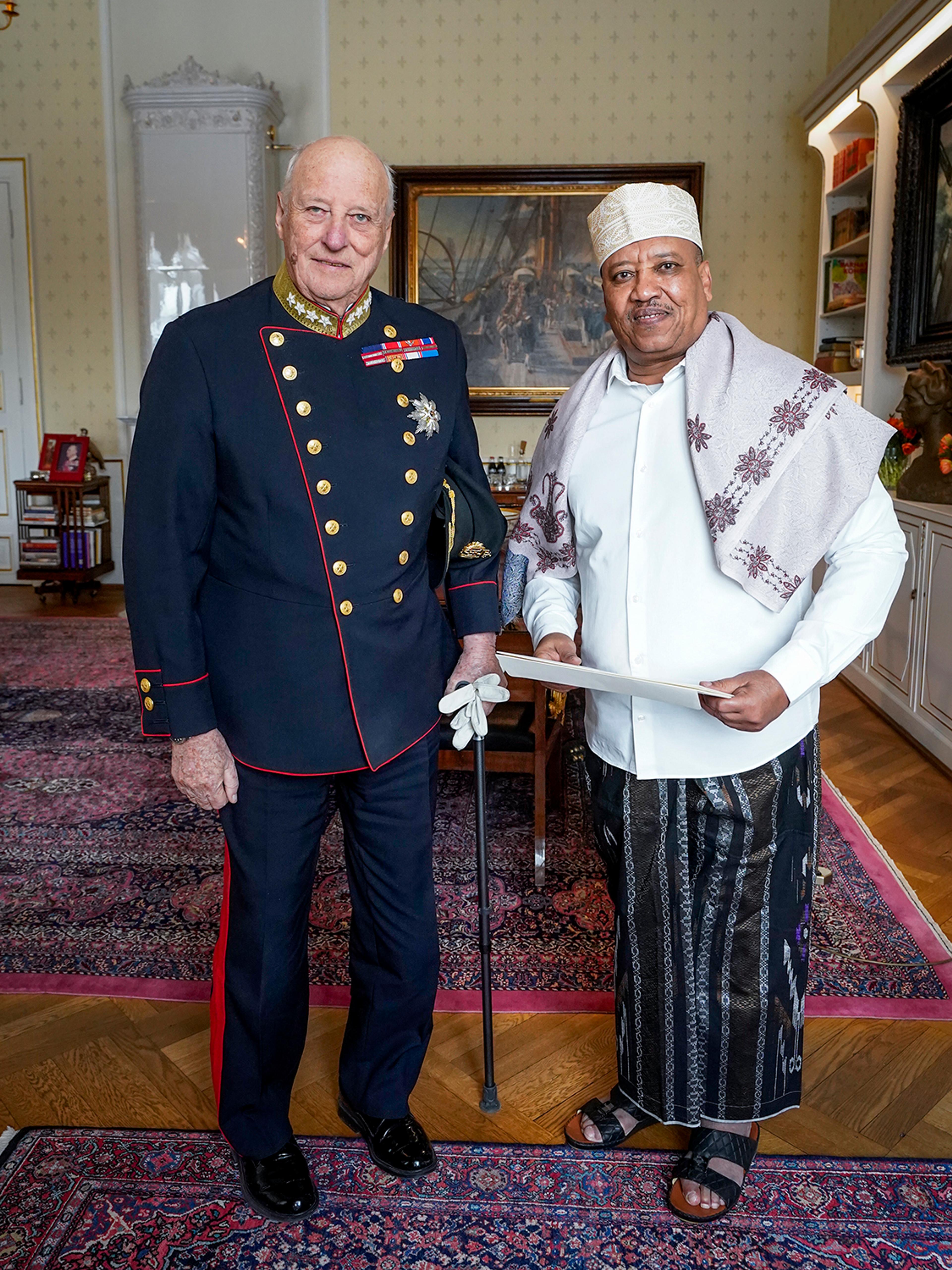 Kongen og ambassadøren står smilende ved siden av hvernadre på Kongens kontor.