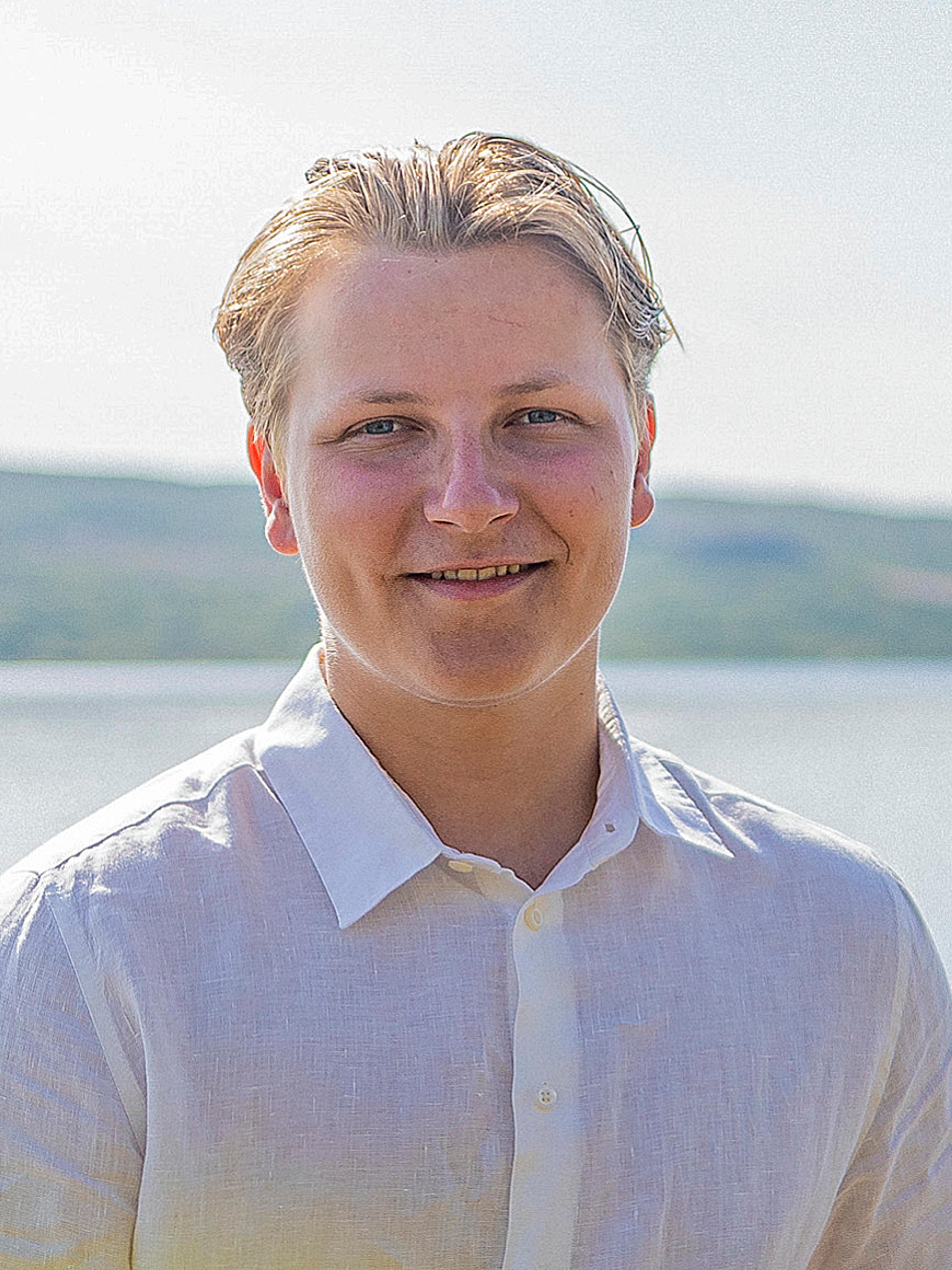 Portrett av Prins Sverre Magnus ikledd en hvit linskjorte, tatt ute på sommeren.