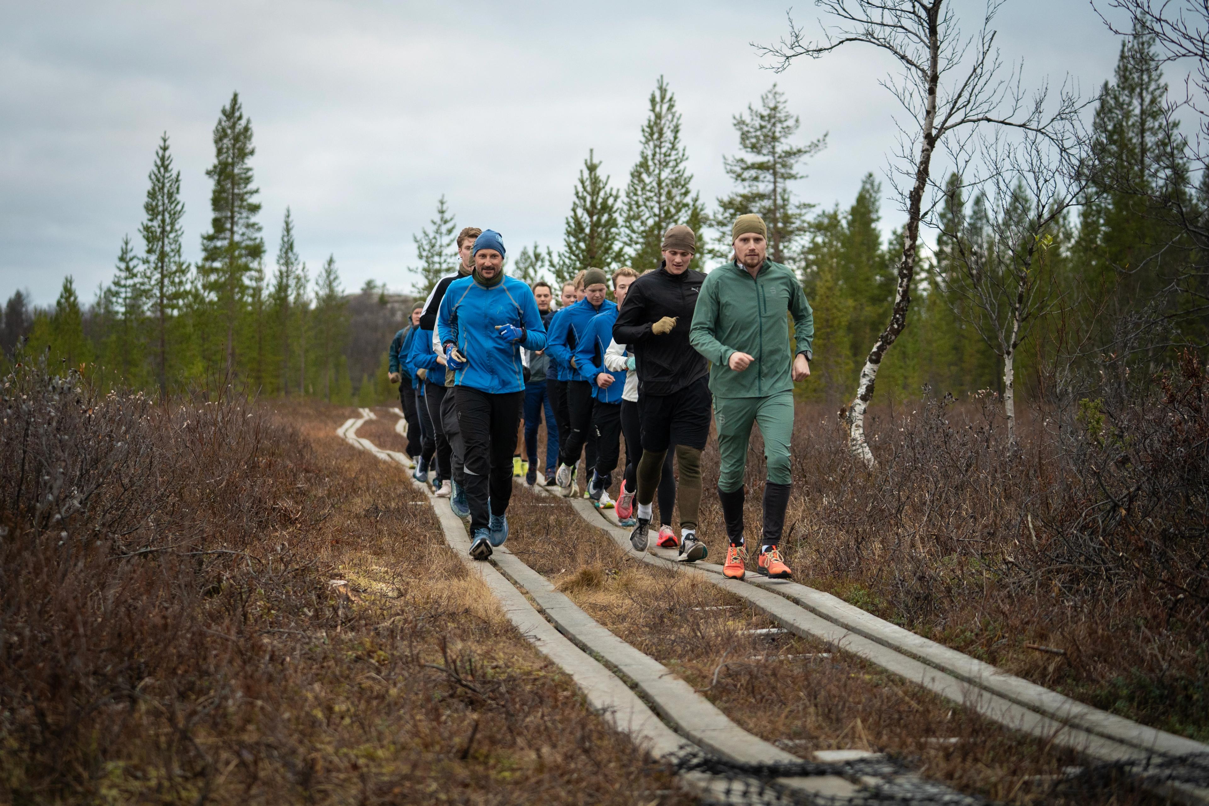 Kongen og de vernepliktige løper på to rekker. Kongen i front på den ene. Alle i treningstøy.