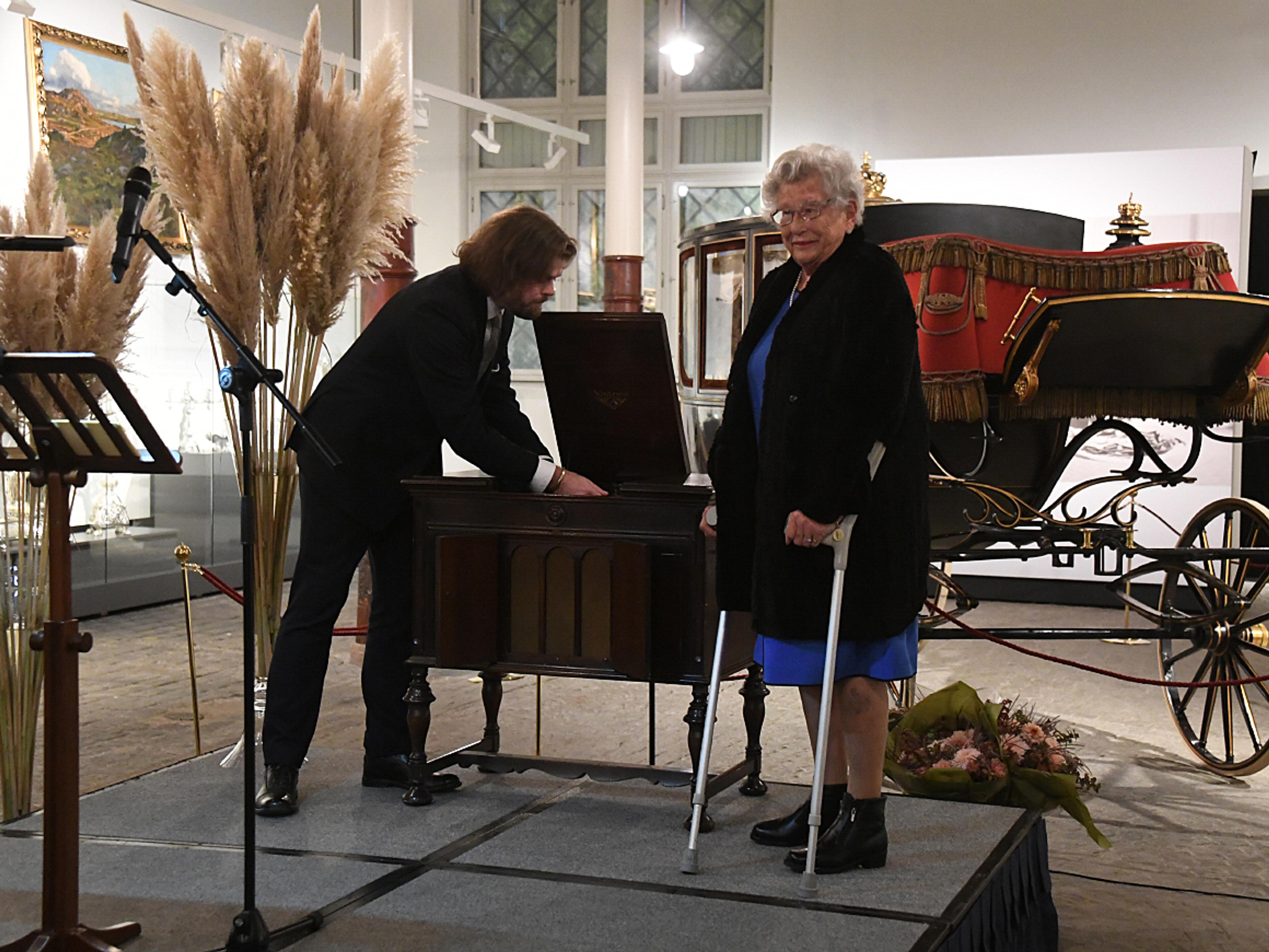 Prinsesse Astrid på scenen sammen med lederen av De kongelige samlinger, som står for utstillingen. De setter i gang en gammel platespiller med foxtrot,
