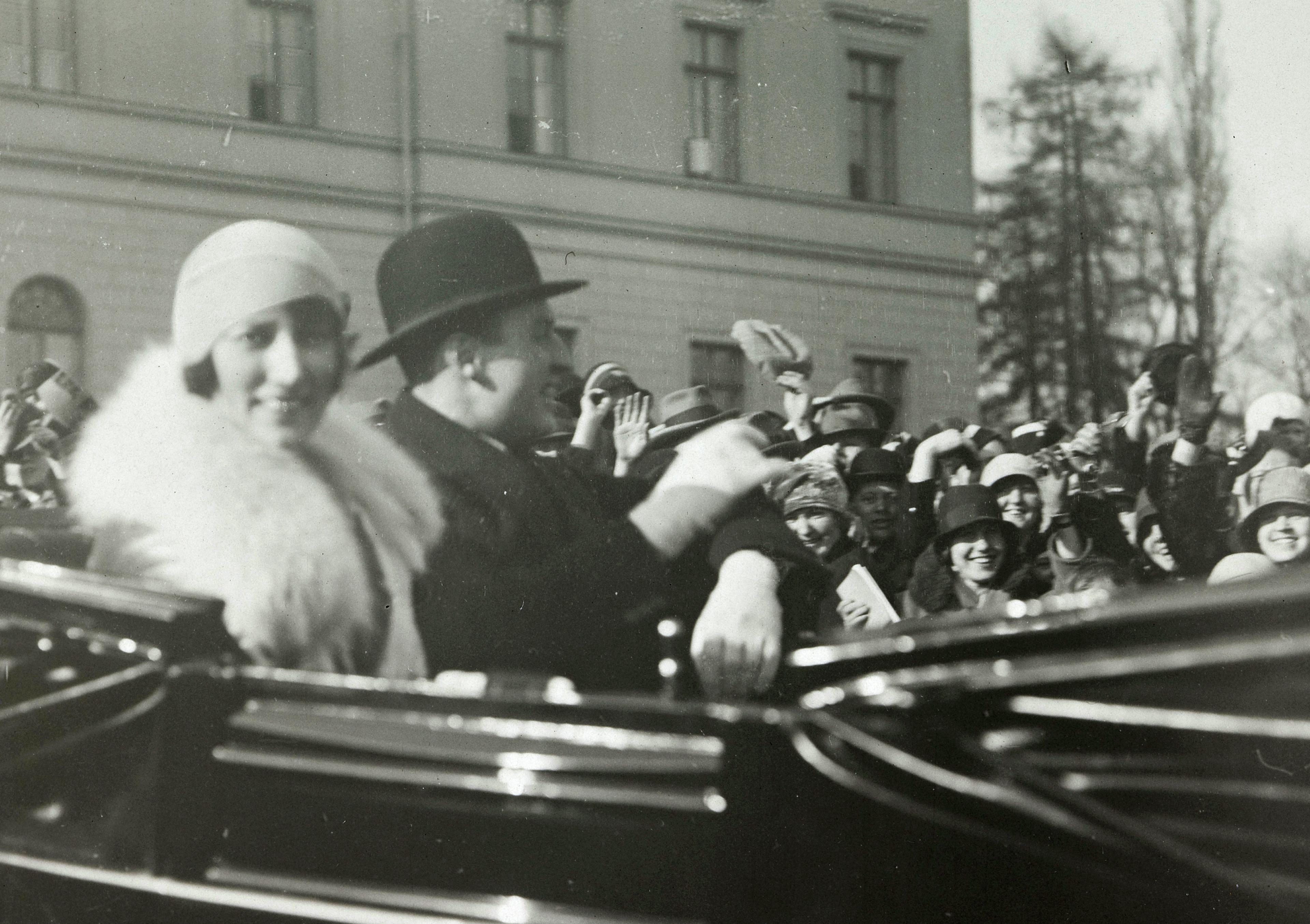 Kronprinsparet vinker fra åpen vogn, en landauer.