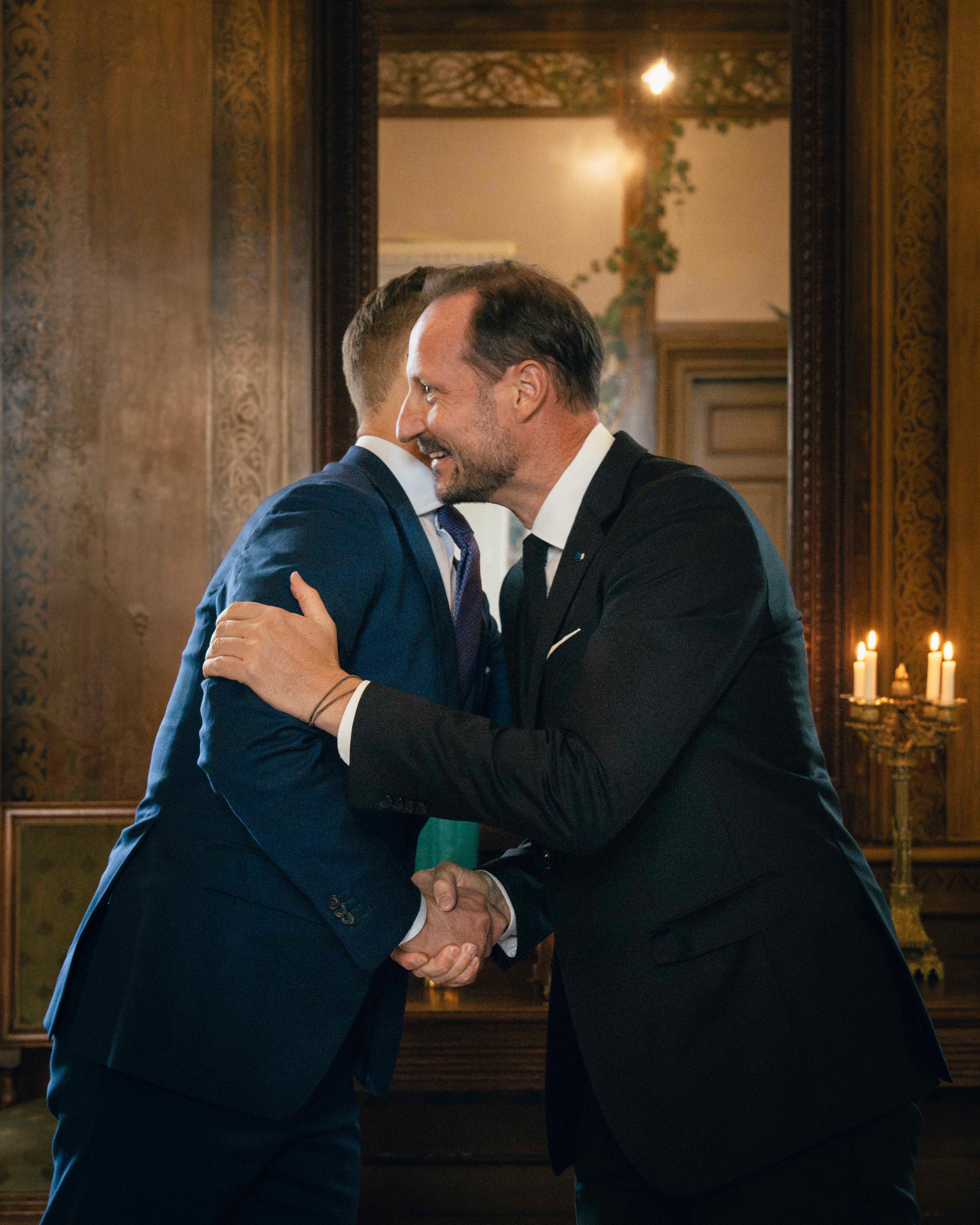 Kong Haakon tar i mot President Alexander Stubb med et håndtrykk og en klem.