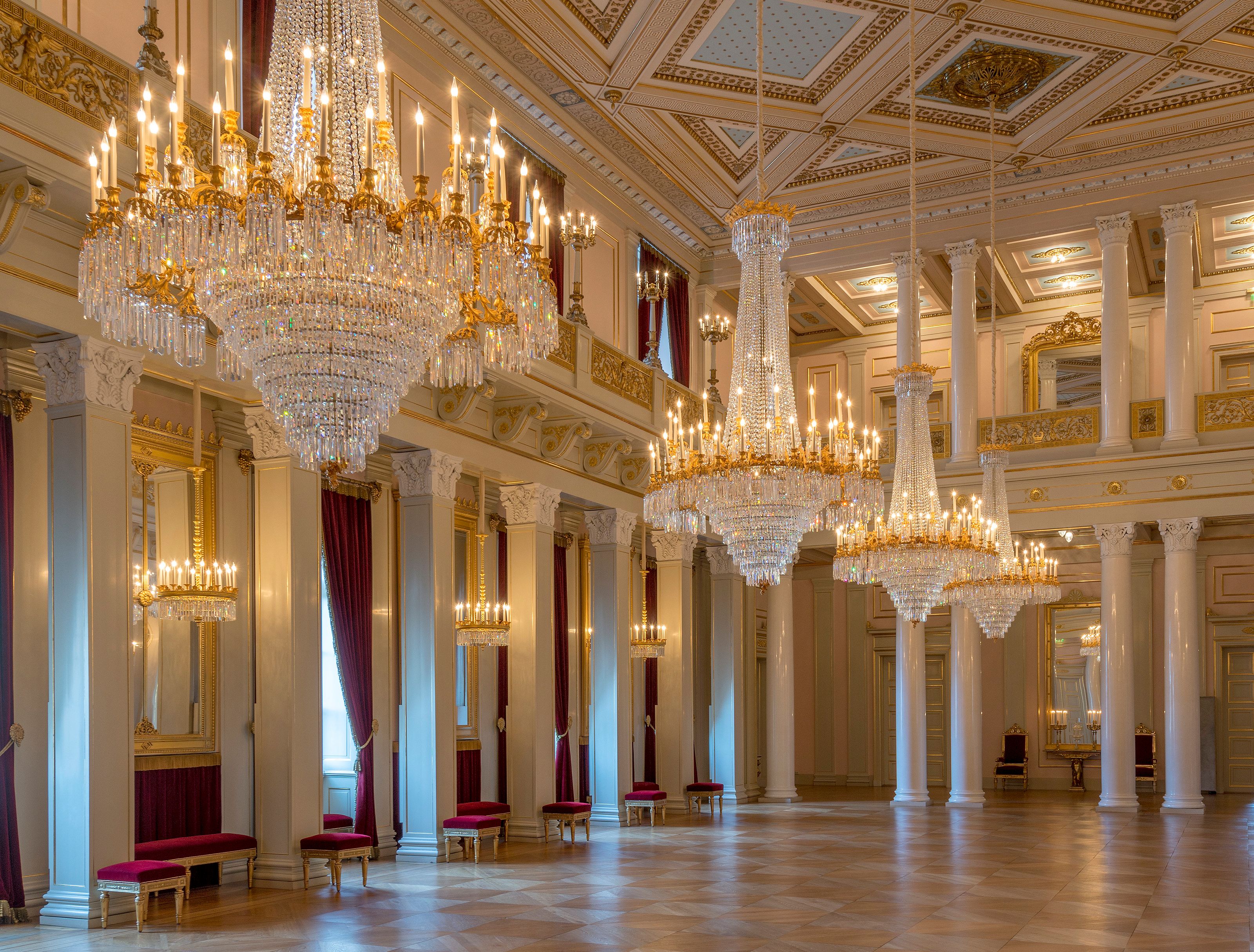 Det er et stort rom, høyt under taket, med dekor i hvitt og gull. Tre enorme lysekroner henger ned fra taket og dominerer værelset.