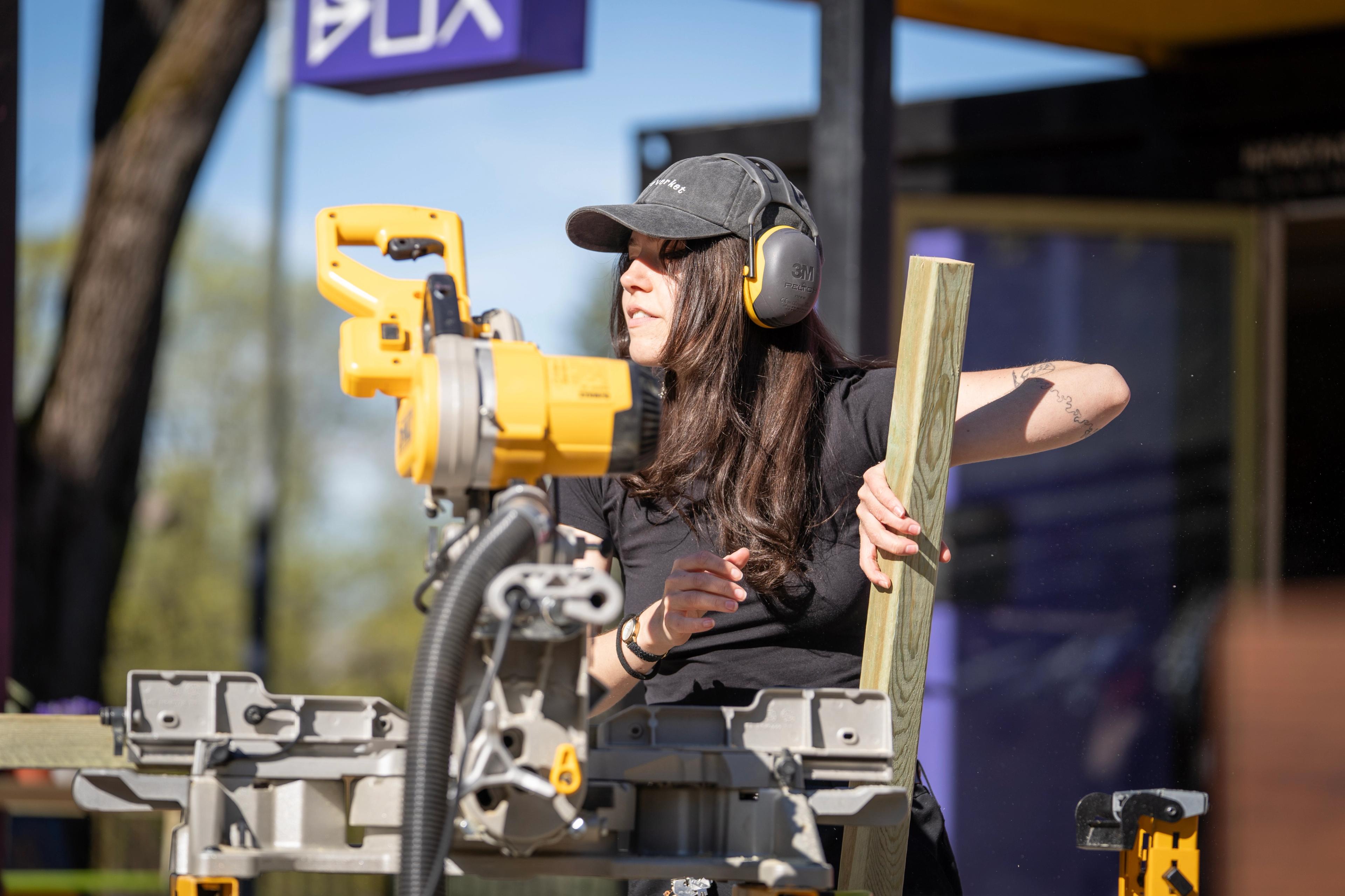 En jente gjør seg klar til å skjære en treplanke.