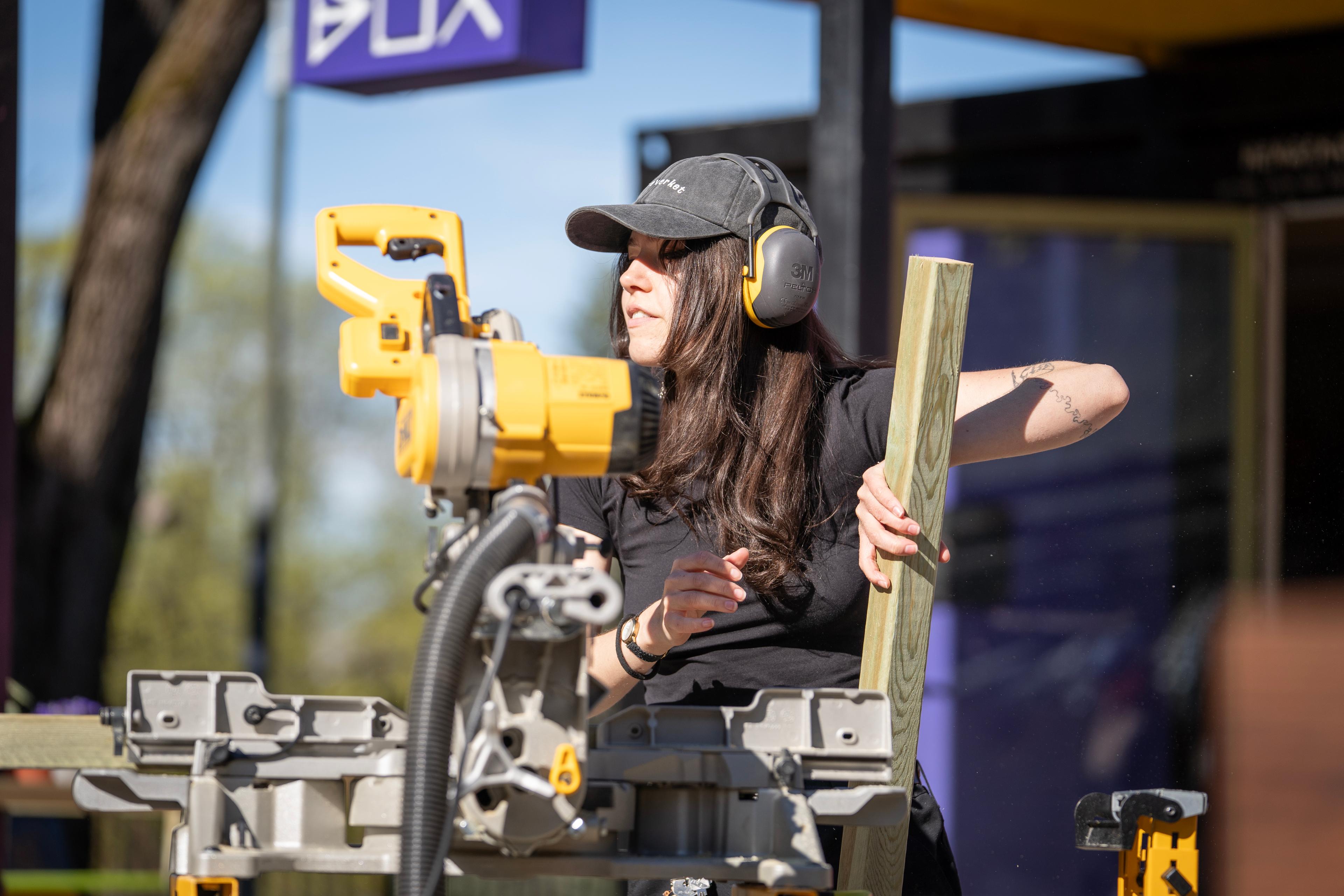 En jente gjør seg klar til å skjære en treplanke.