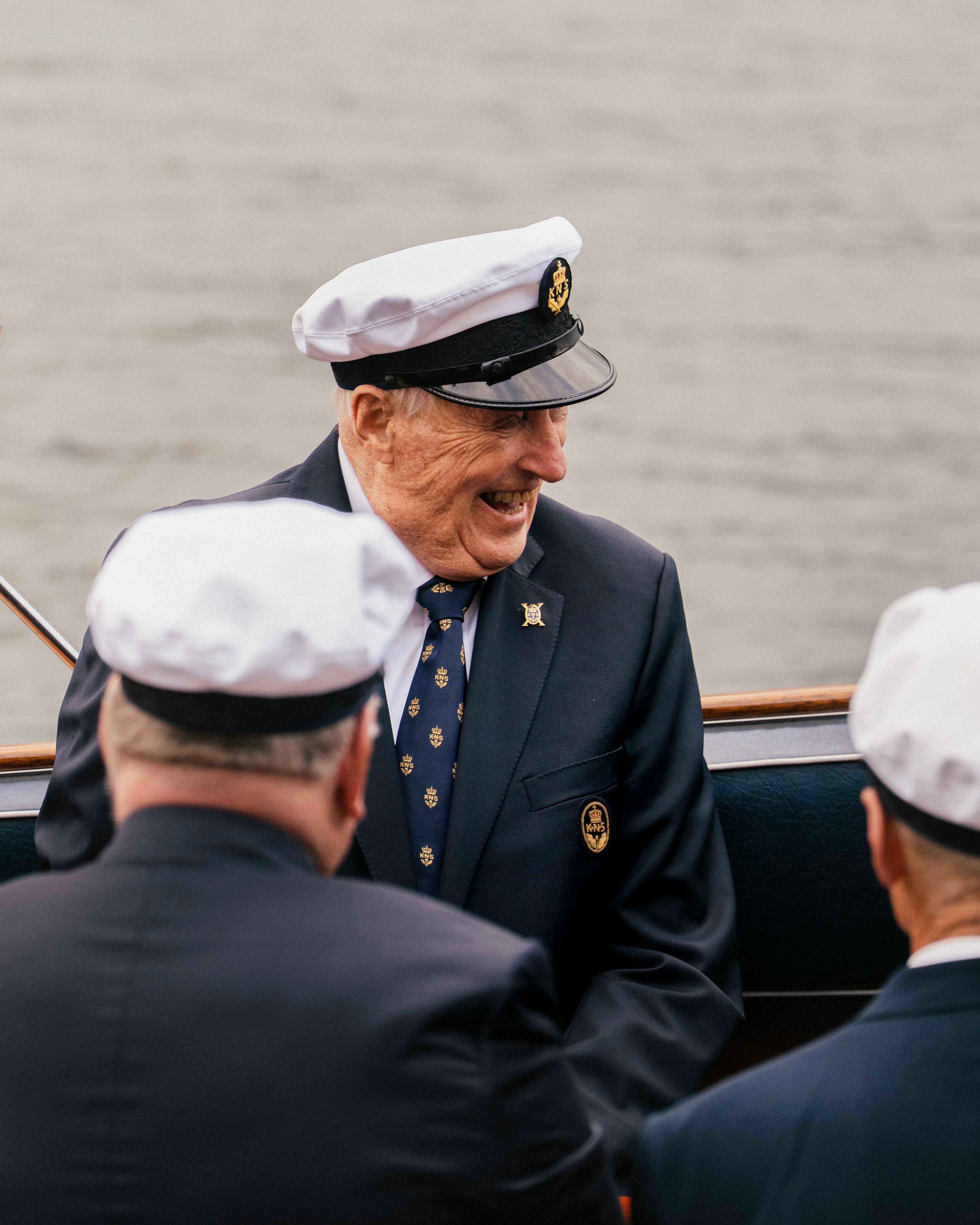 Kong Harlad sitter i Kongebåten Stjernen med et stort smil