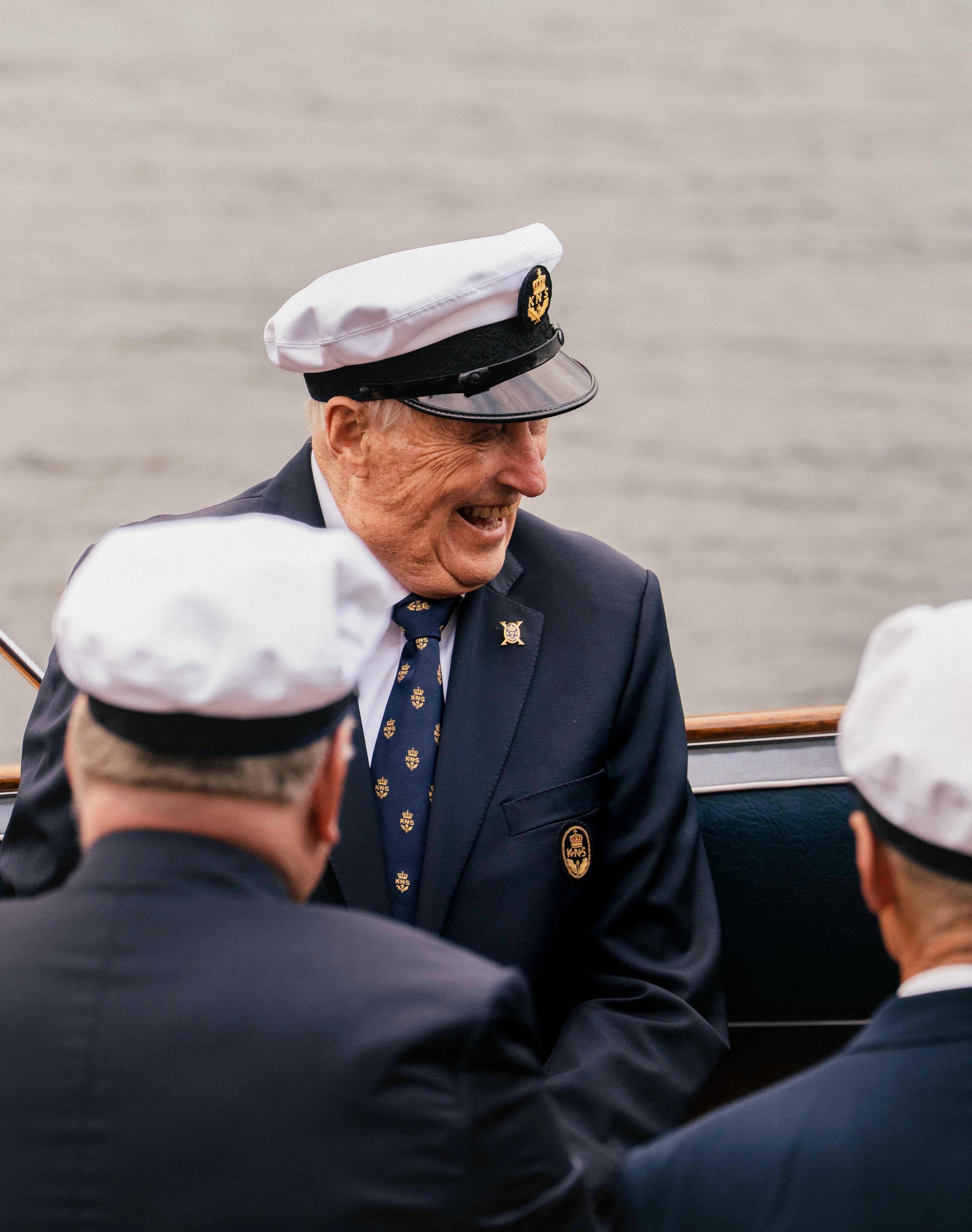 Kong Harlad sitter i Kongebåten Stjernen med et stort smil