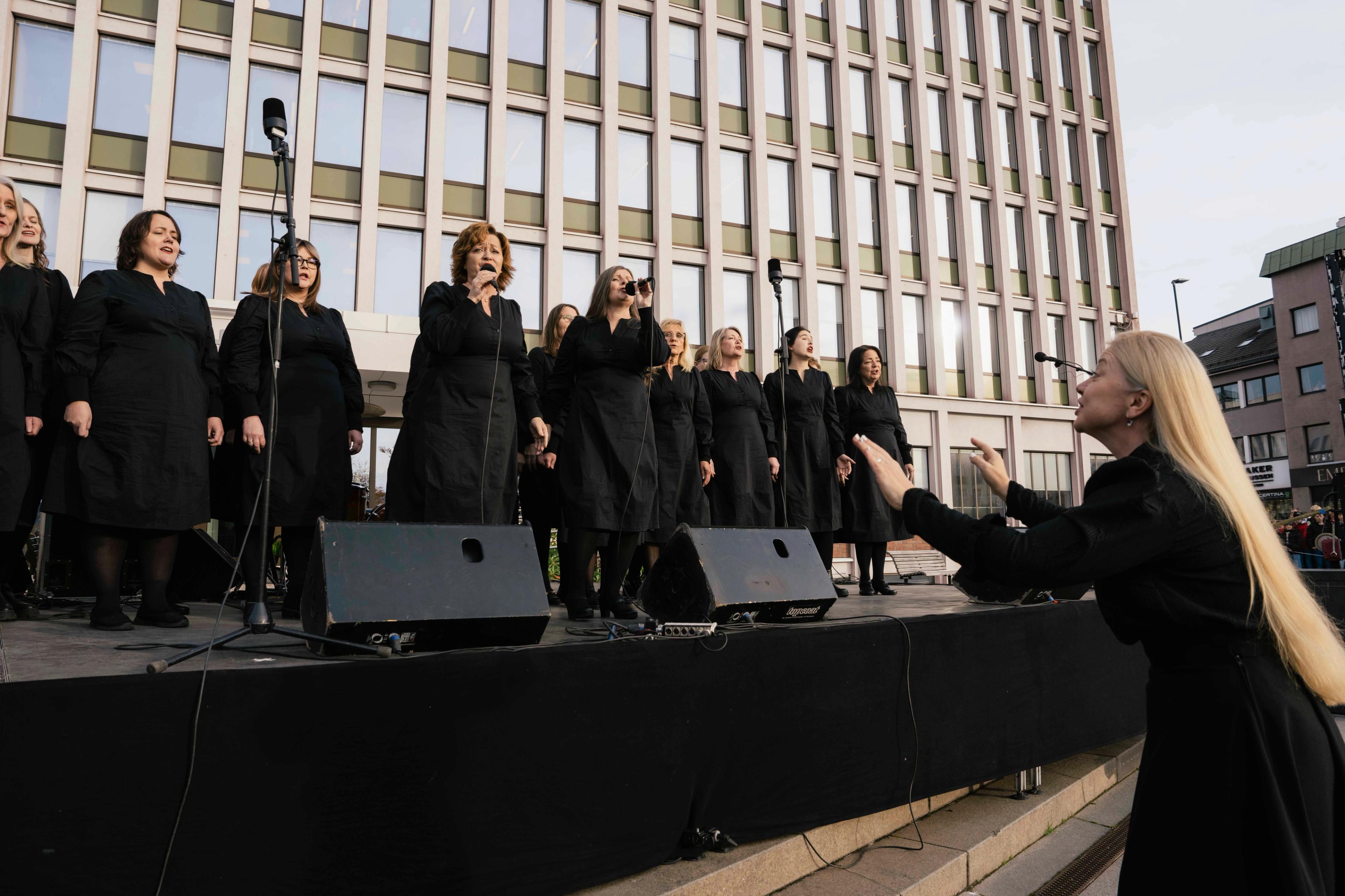 Damerkoret står på scenen og synger