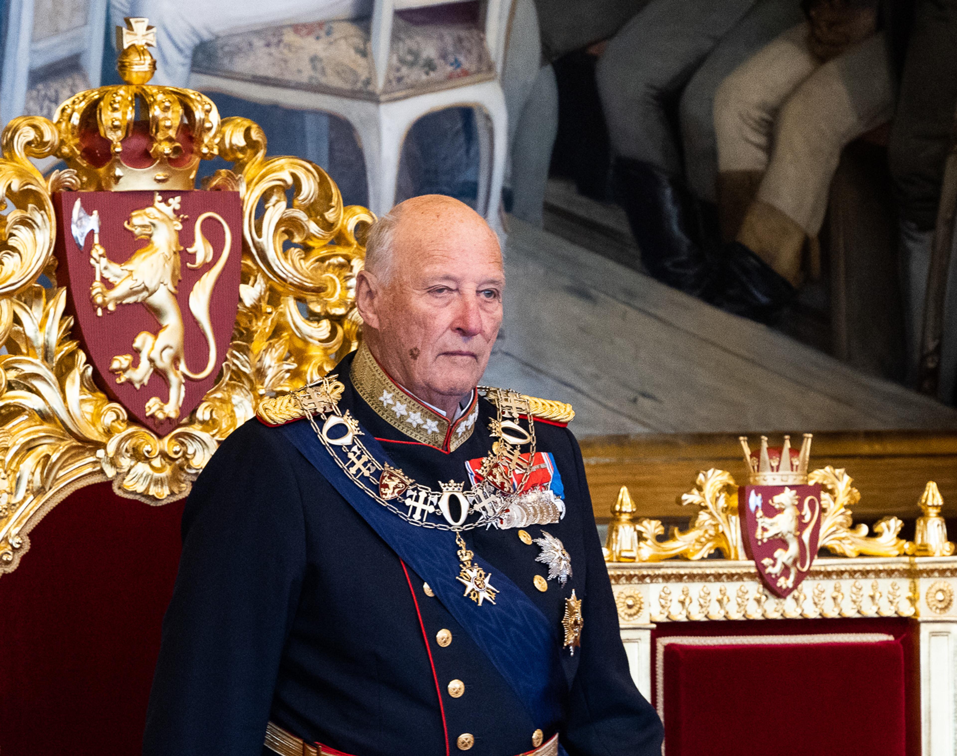 Kont Harald står i gallauniform foran tronstolen i rødt og gull, med Riksvåpenet bak.