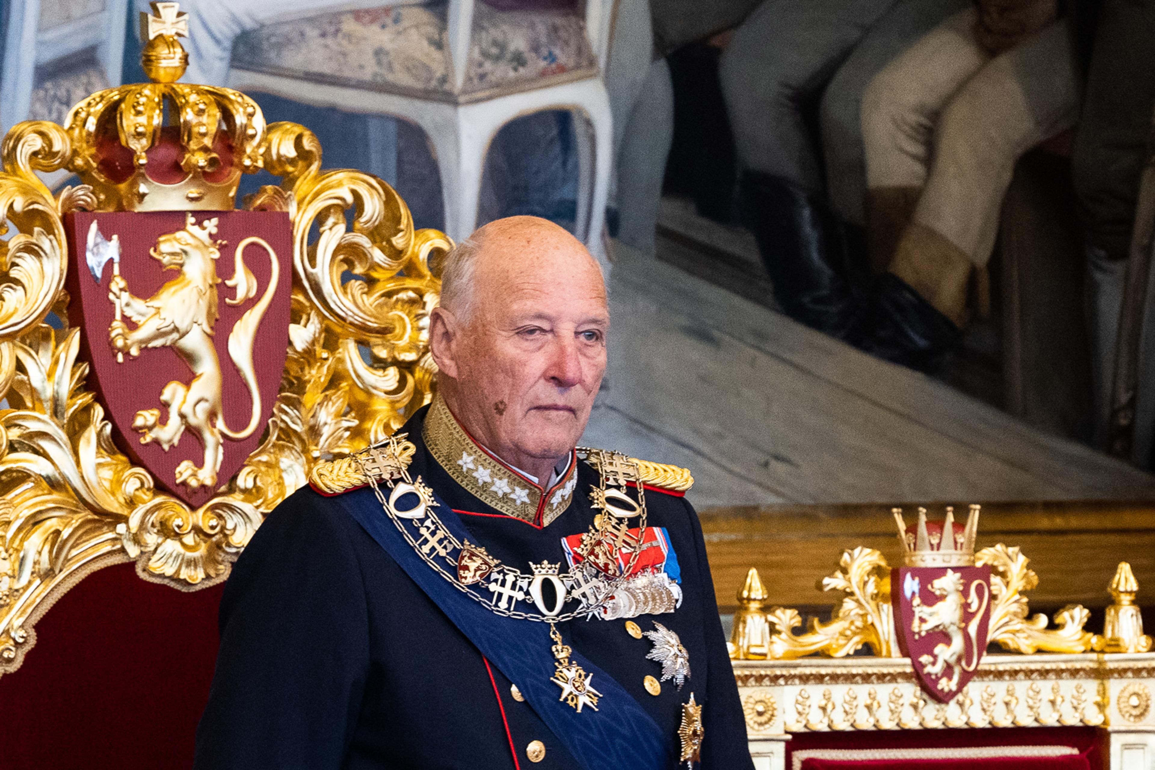 Kont Harald står i gallauniform foran tronstolen i rødt og gull, med Riksvåpenet bak.