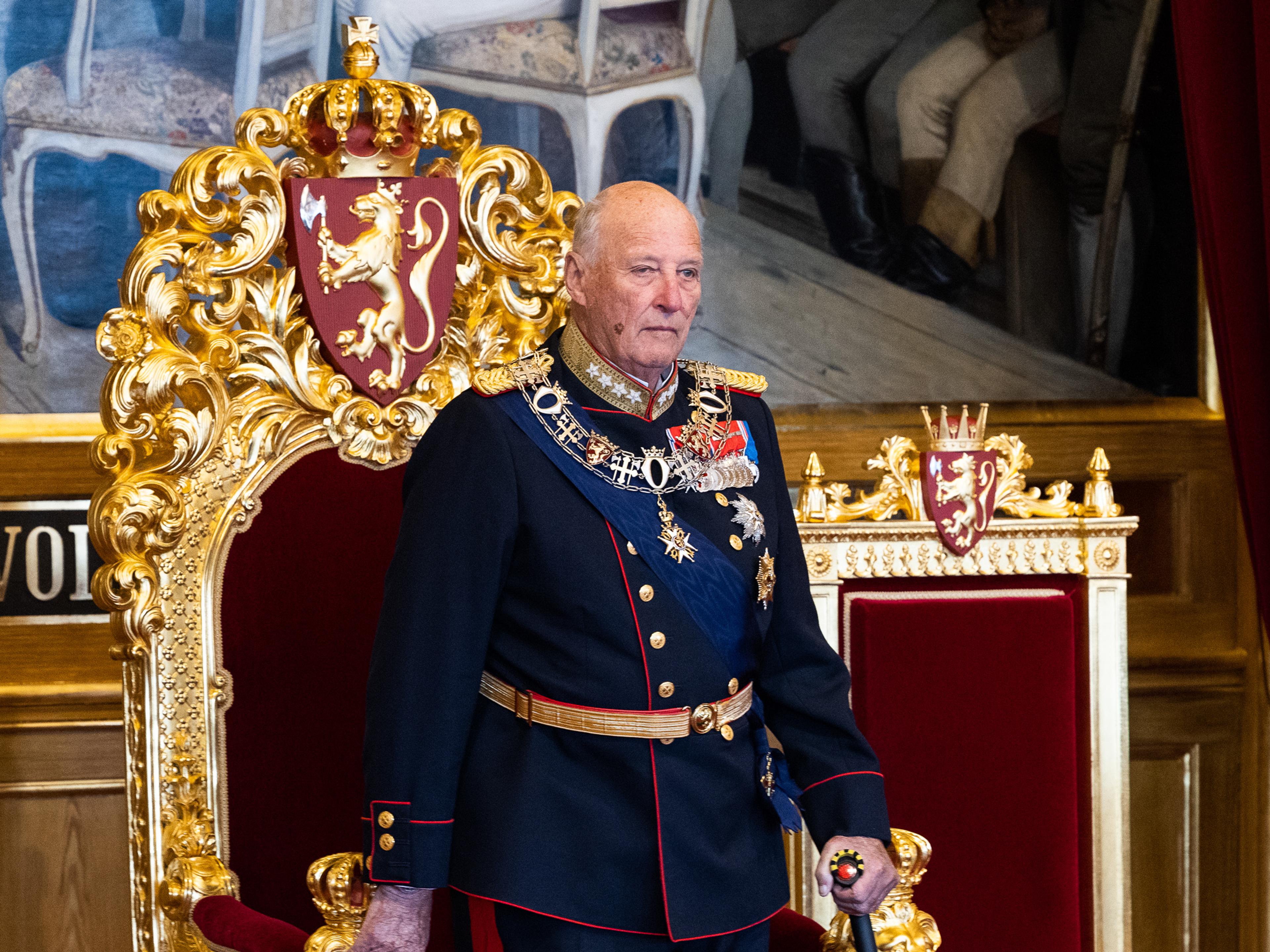 Kont Harald står i gallauniform foran tronstolen i rødt og gull, med Riksvåpenet bak.
