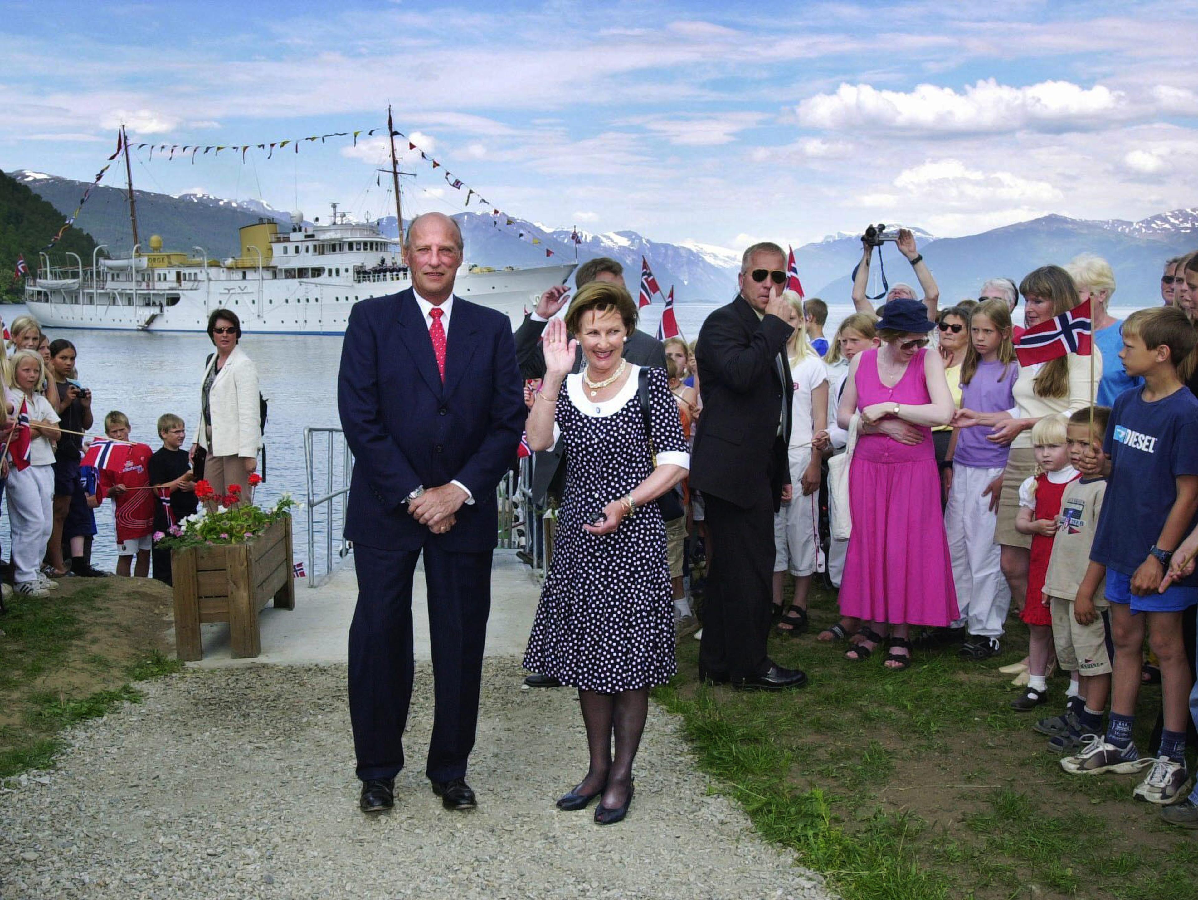 Kongeparet tar farvel med befolkningen på kaia. I bakgrunnen ses kongeskipet ''Norge''.