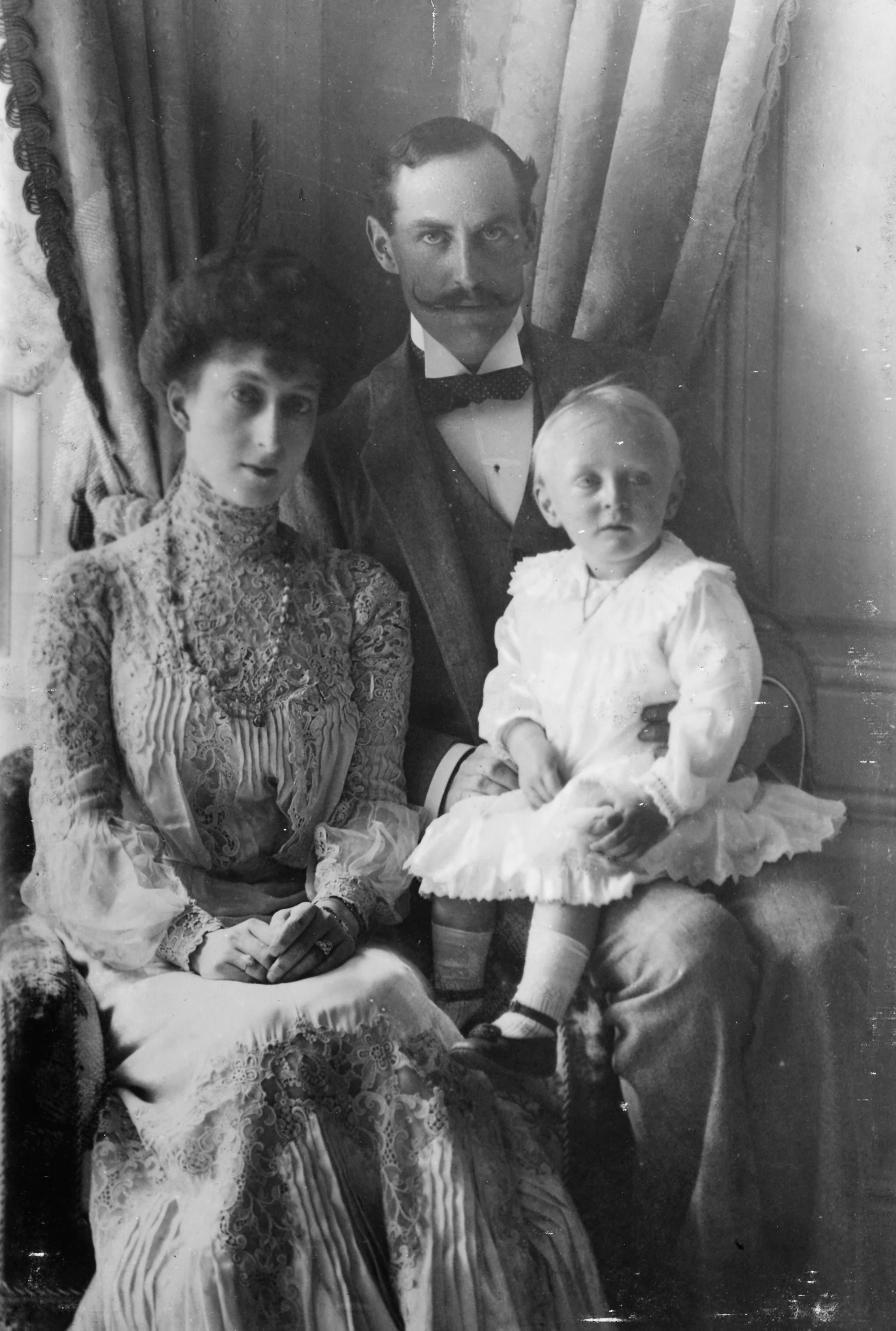 Kong Haakon og Dronning Maud i 1905. Kongen har den unge Kronprins Olav på fanget.