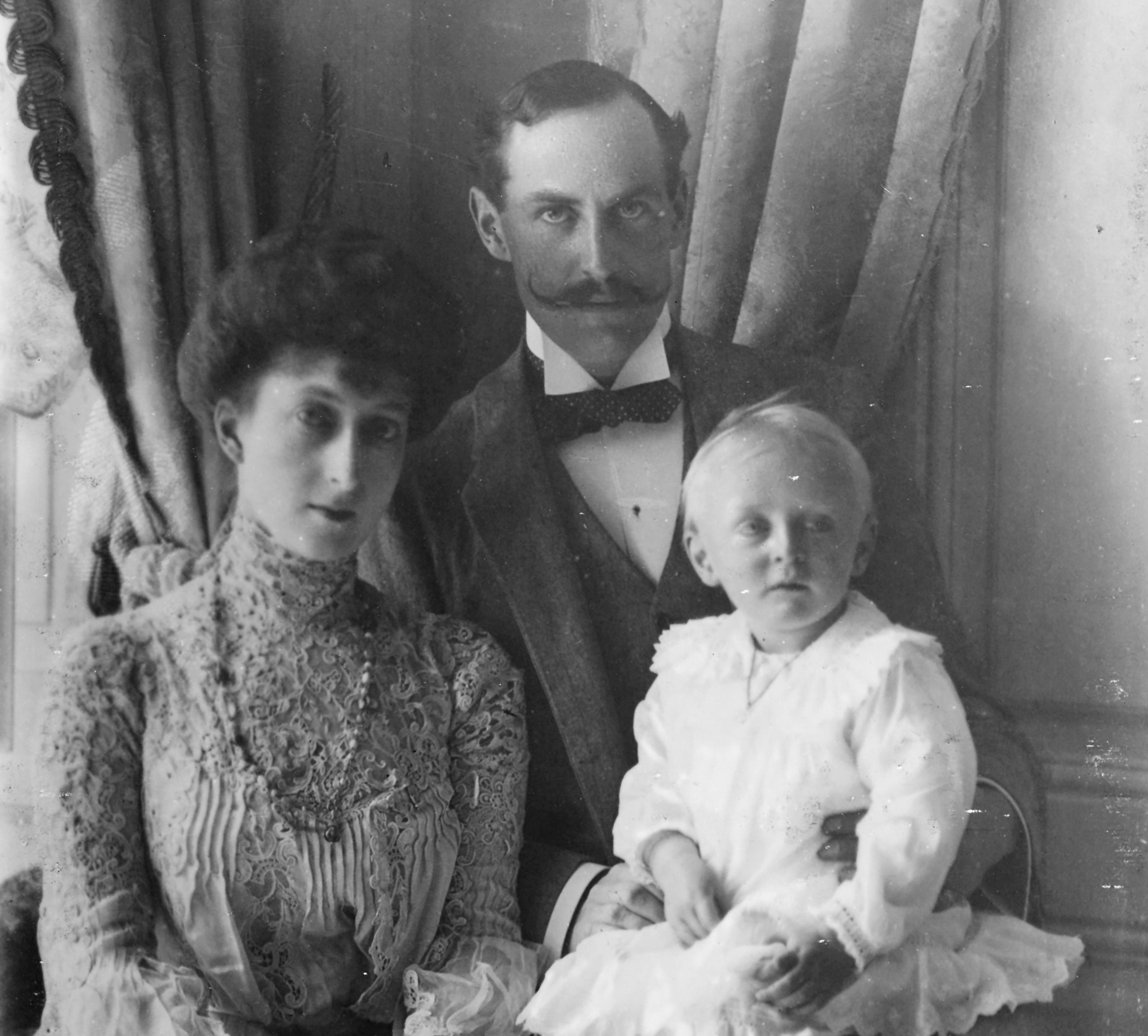 Kong Haakon og Dronning Maud i 1905. Kongen har den unge Kronprins Olav på fanget.
