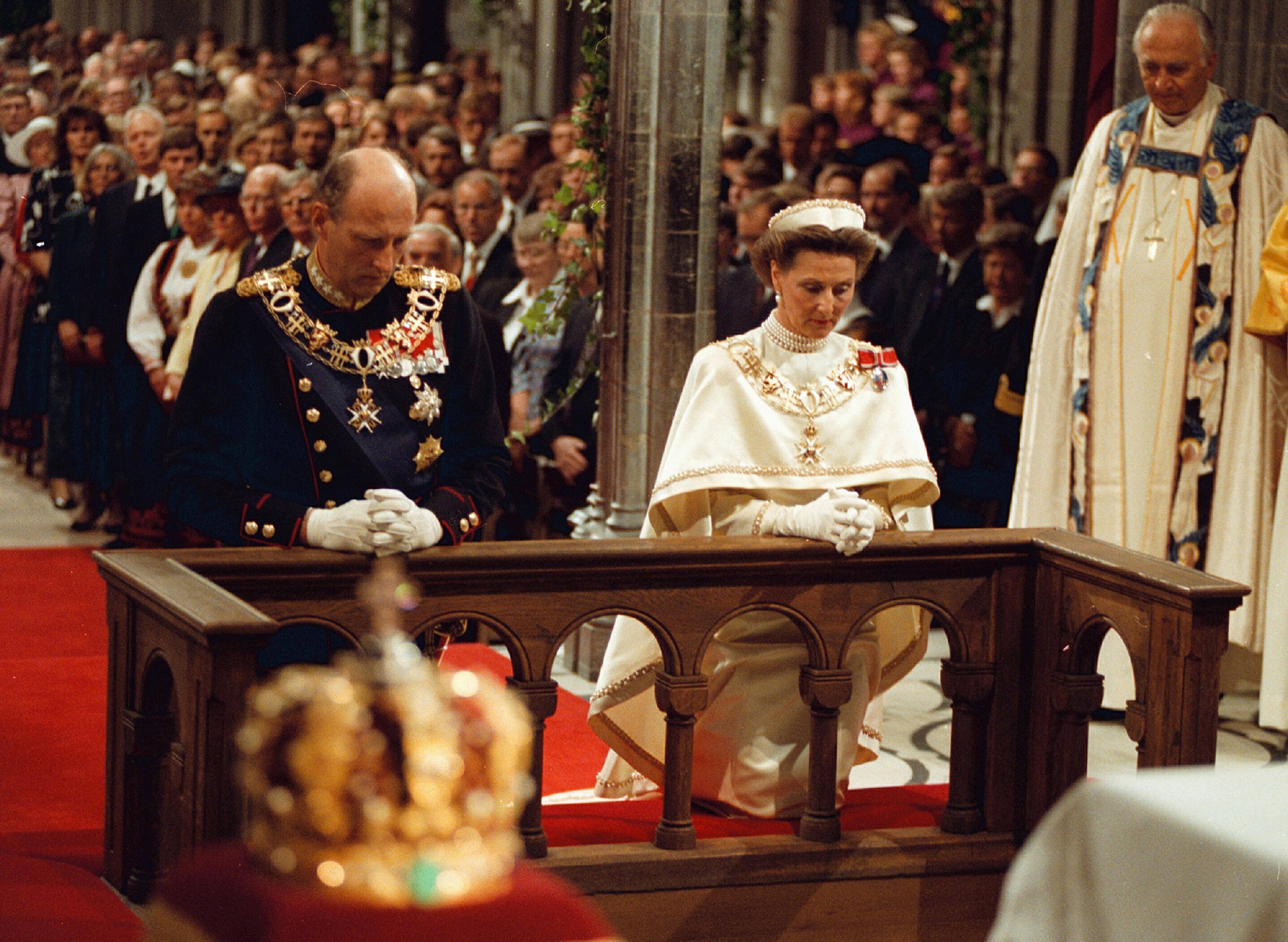Kong Harald og Dronning Sonja kneler ved alteret i Nidarosdomen.