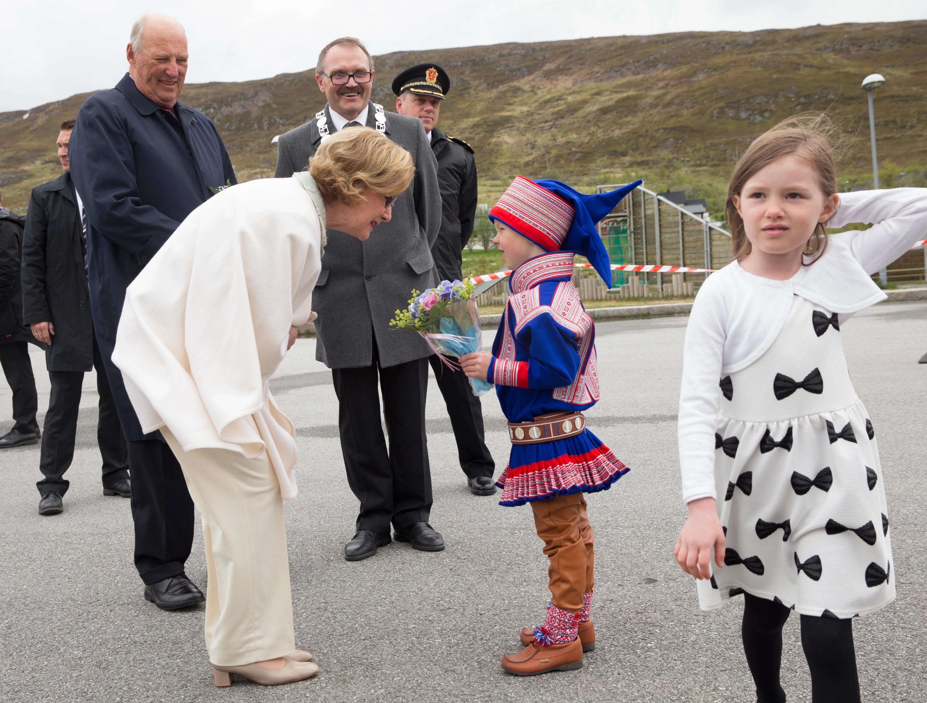 Dronning Sonja snakker med Ailo Mathis Lægland Eiro i vakker blå guttekofte.