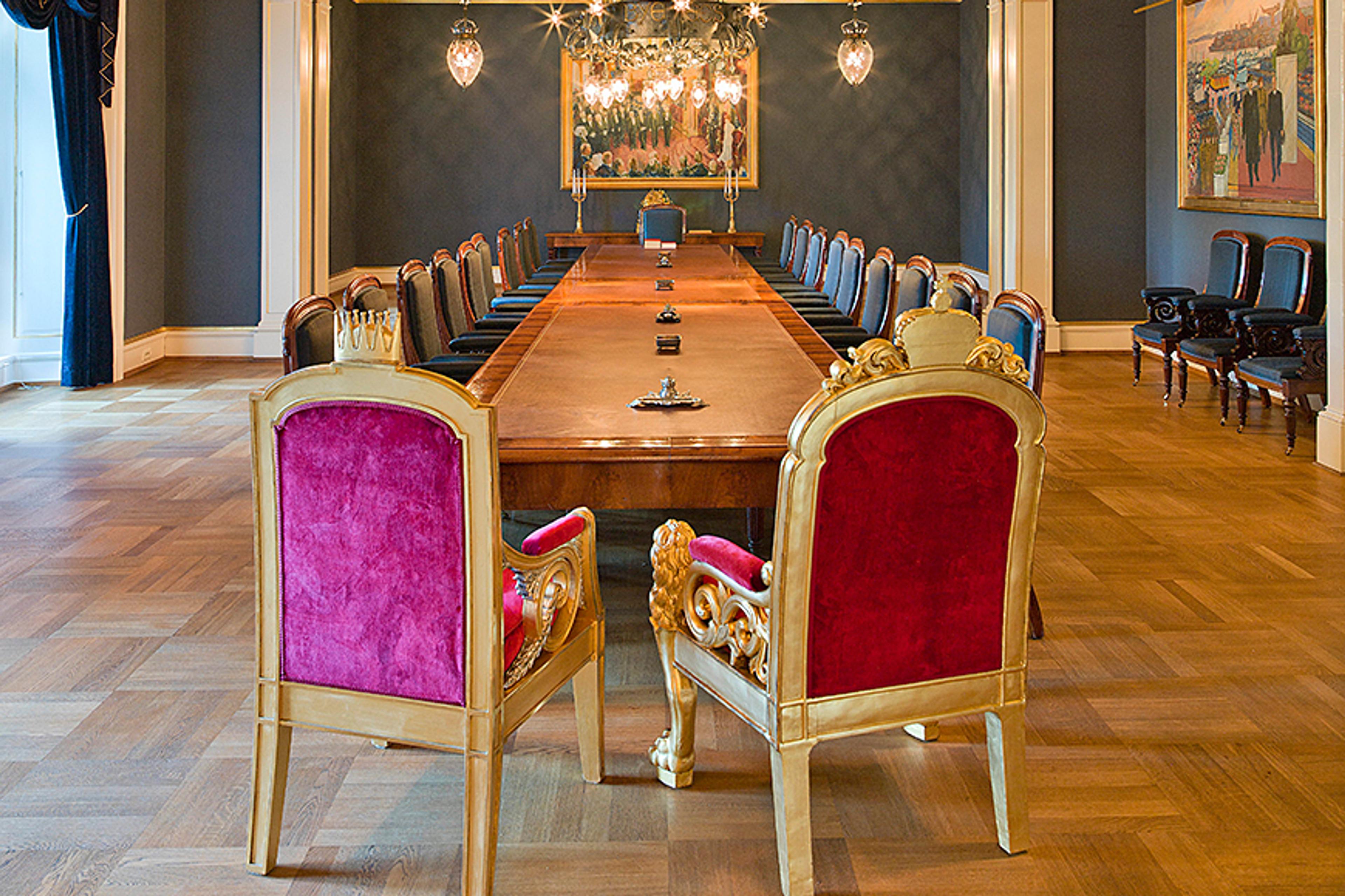 En tom statsrådsal sett fra enden av bordet der Kongen har sin plass.