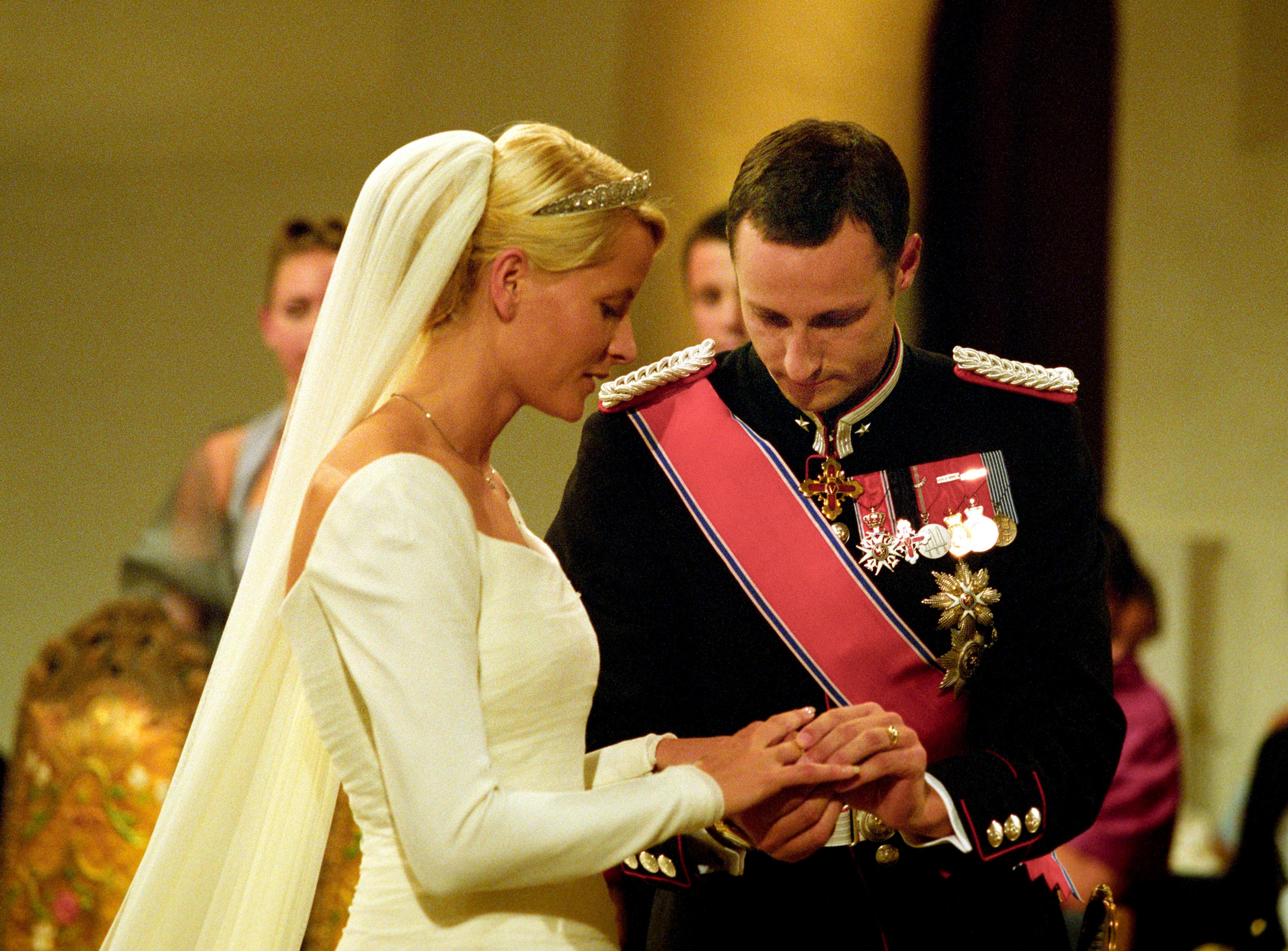 Kronprins Haakon og Kronprinsesse Mette-Marit står ved alteret.